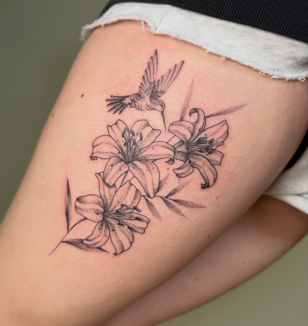 Lilies and hummingbird dotwork tattoo on the thigh by Koryn Donnelly