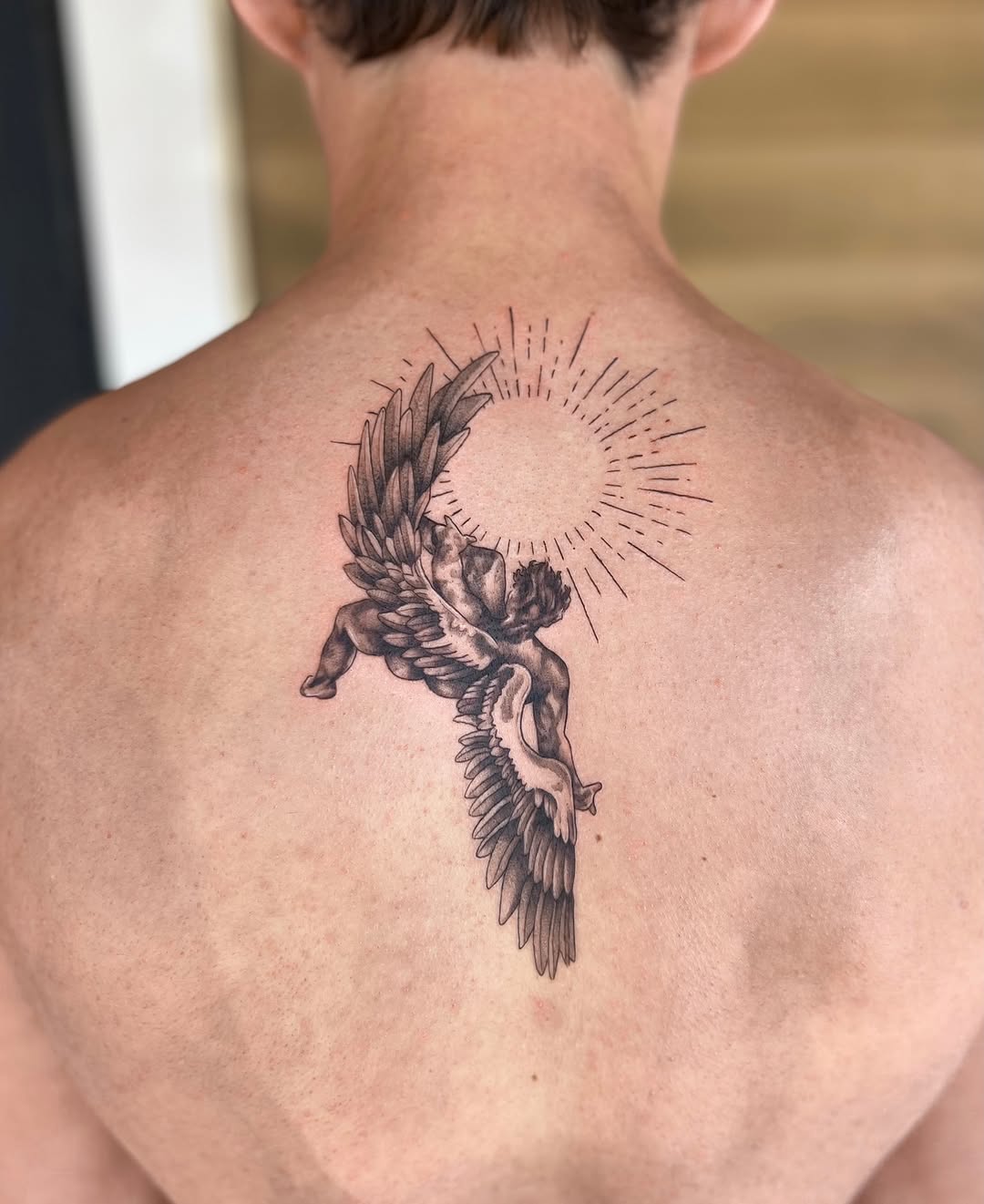 Angel with sun rays realism tattoo on the back by Jai Woods