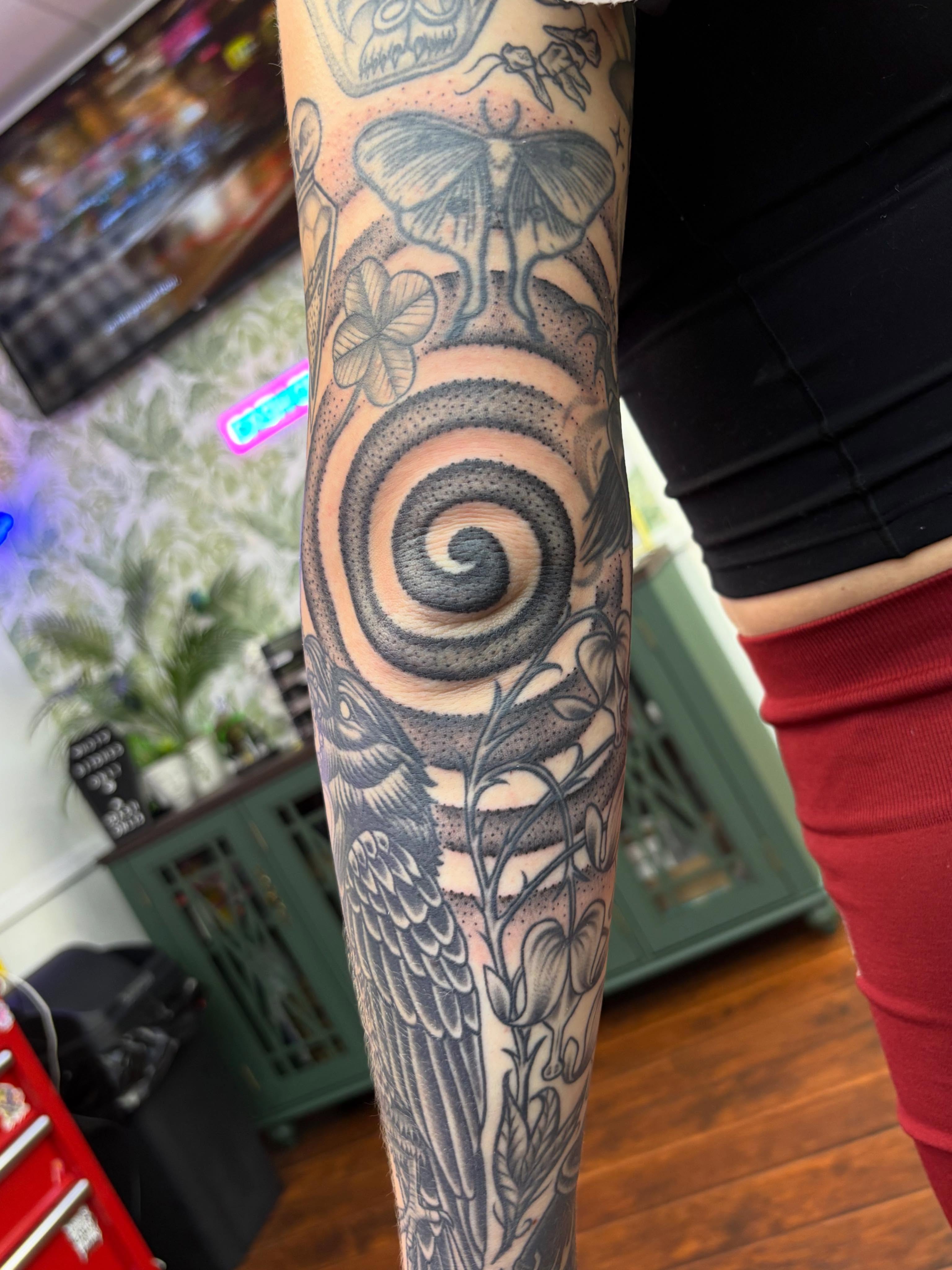 Spiral and bird dotwork tattoo on the forearm by Skye California