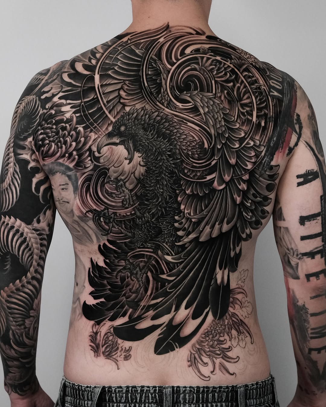 Eagle and chrysanthemum realism tattoo on the back by Yujin Ju