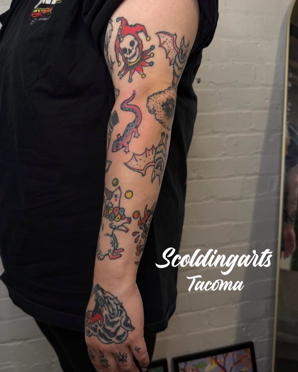 Jester skull and lizard American traditional tattoo on the forearm by Dennis Patterson