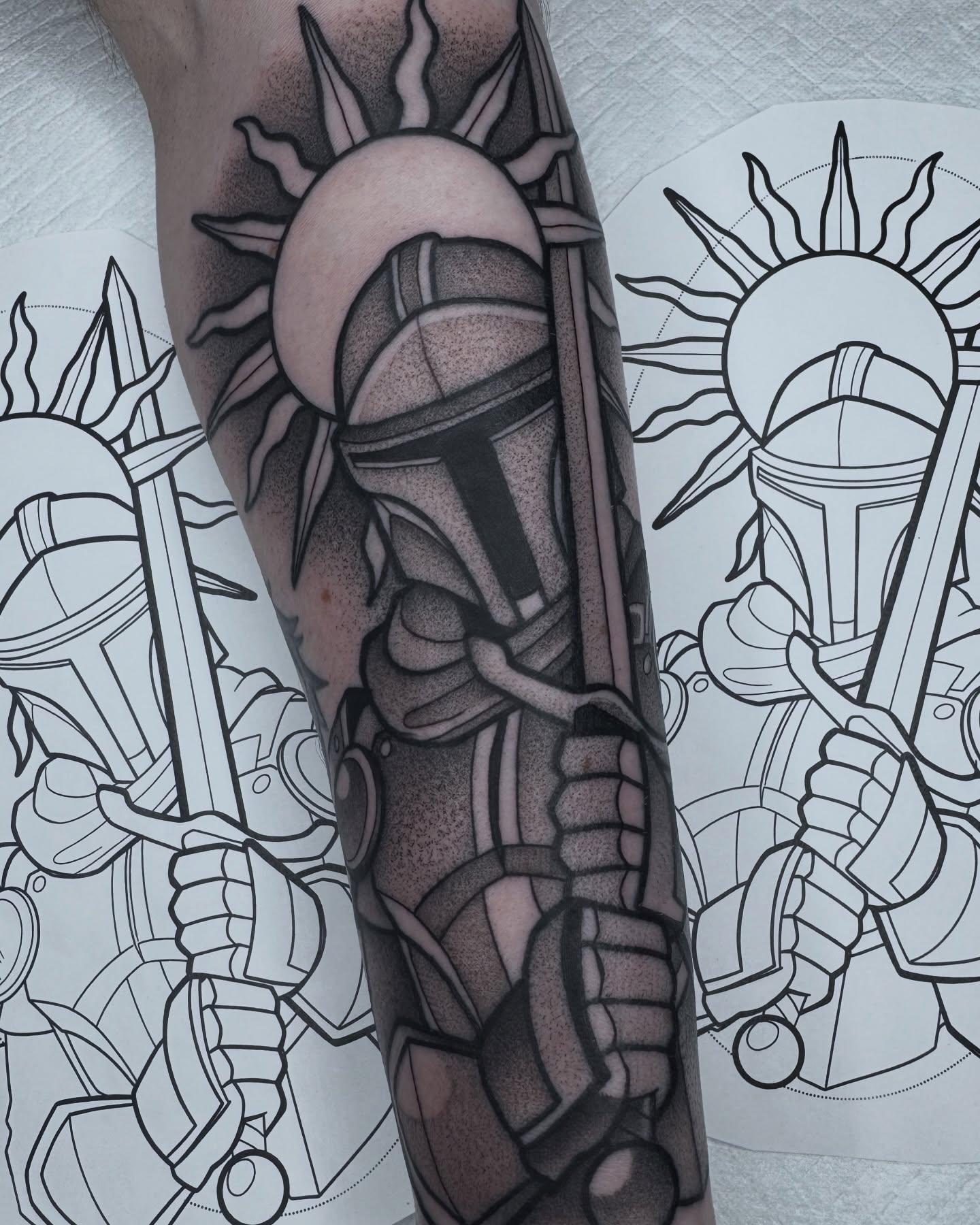 Mandalorian helmet black and grey tattoo on the forearm by Donnie Moore