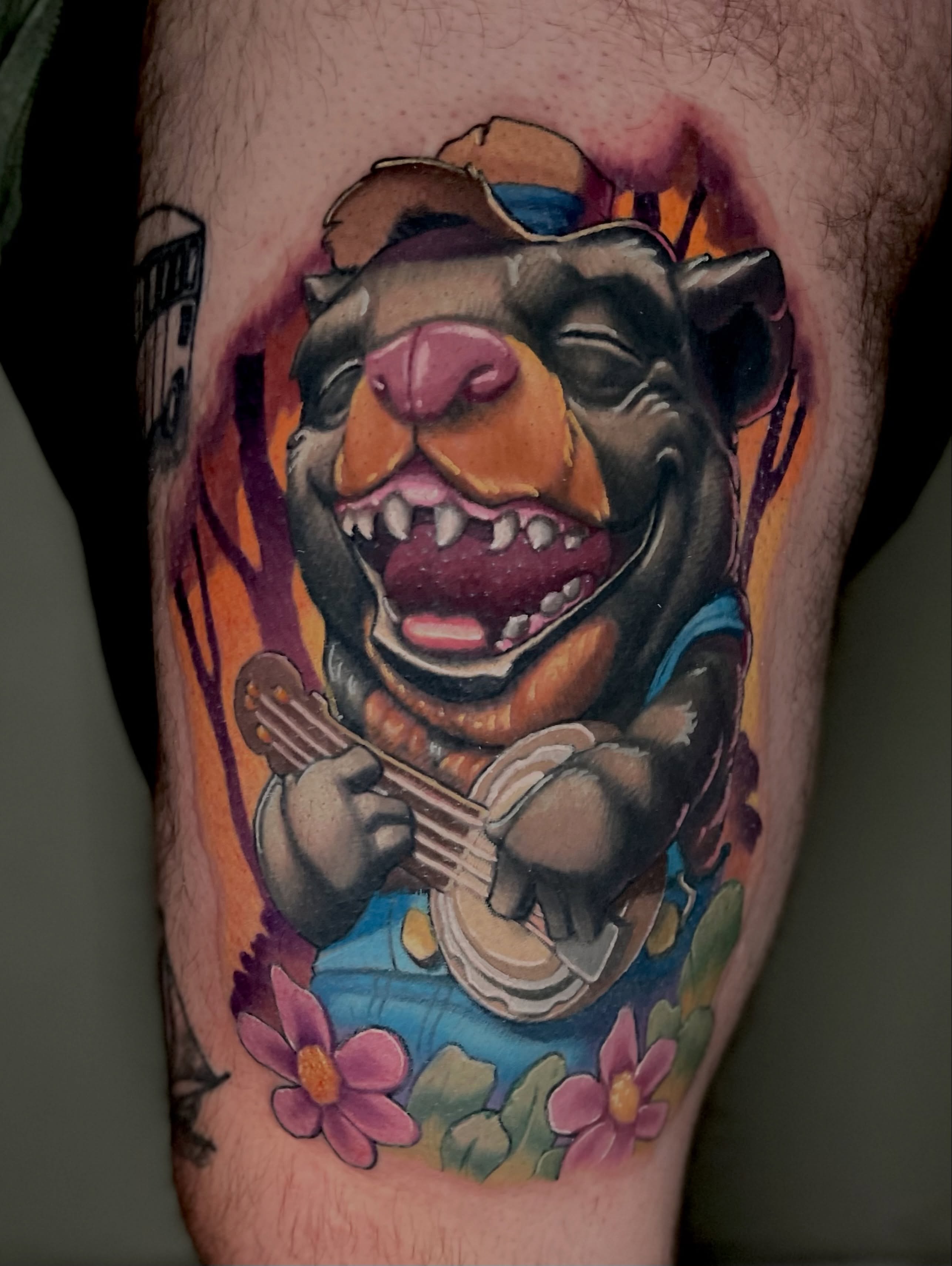 Bear playing banjo realism tattoo on the thigh by Jacob Webb