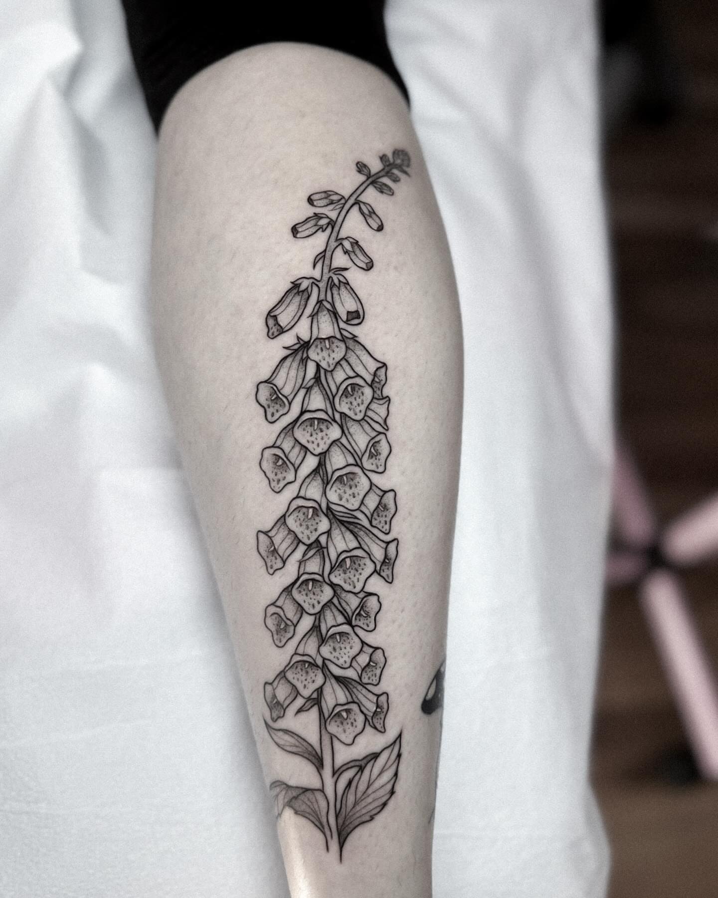 Foxglove plant black and grey tattoo on the calf by Whimsical Tattoos