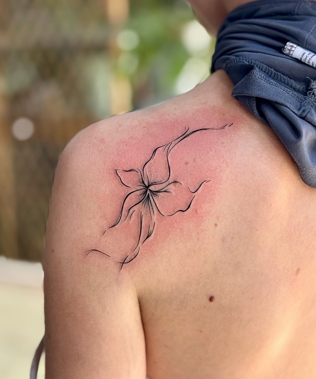 Abstract flower minimalist tattoo on the shoulder by Emily Velletta, Huntersville, North Carolina