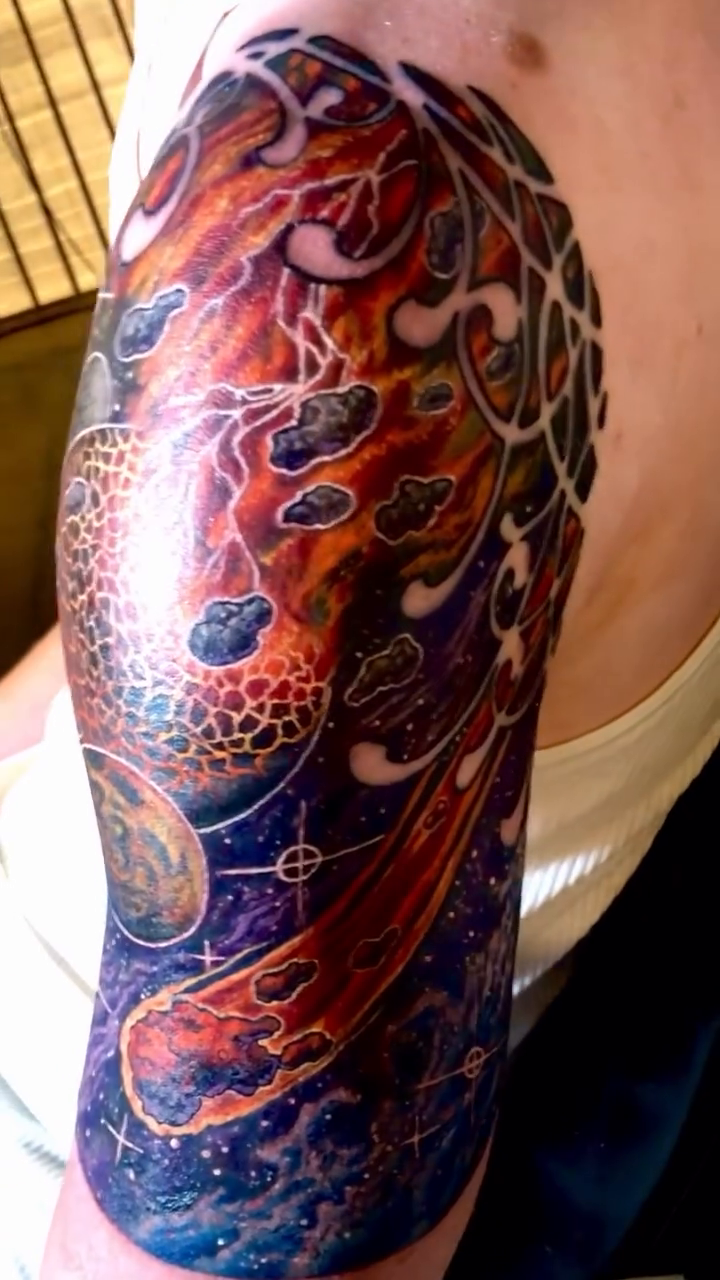 Watercolor tattoo on the upper arm by Patrick Delvar