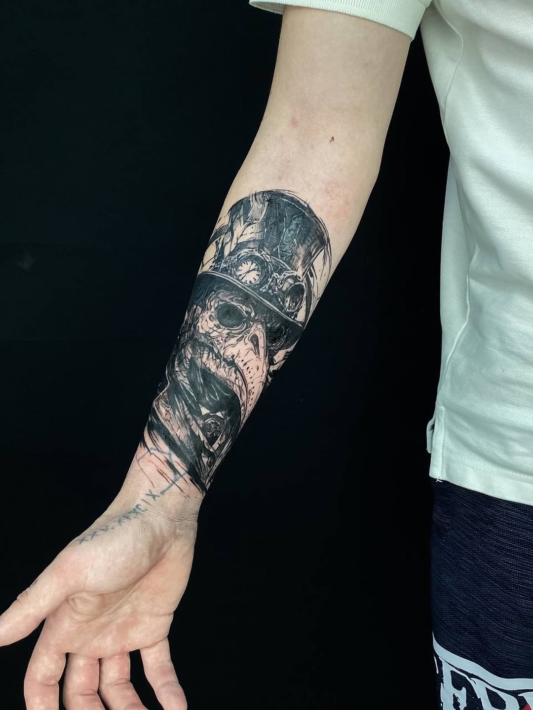 Skull with top hat and goggles realism tattoo on the forearm by Alexey Molyarenko