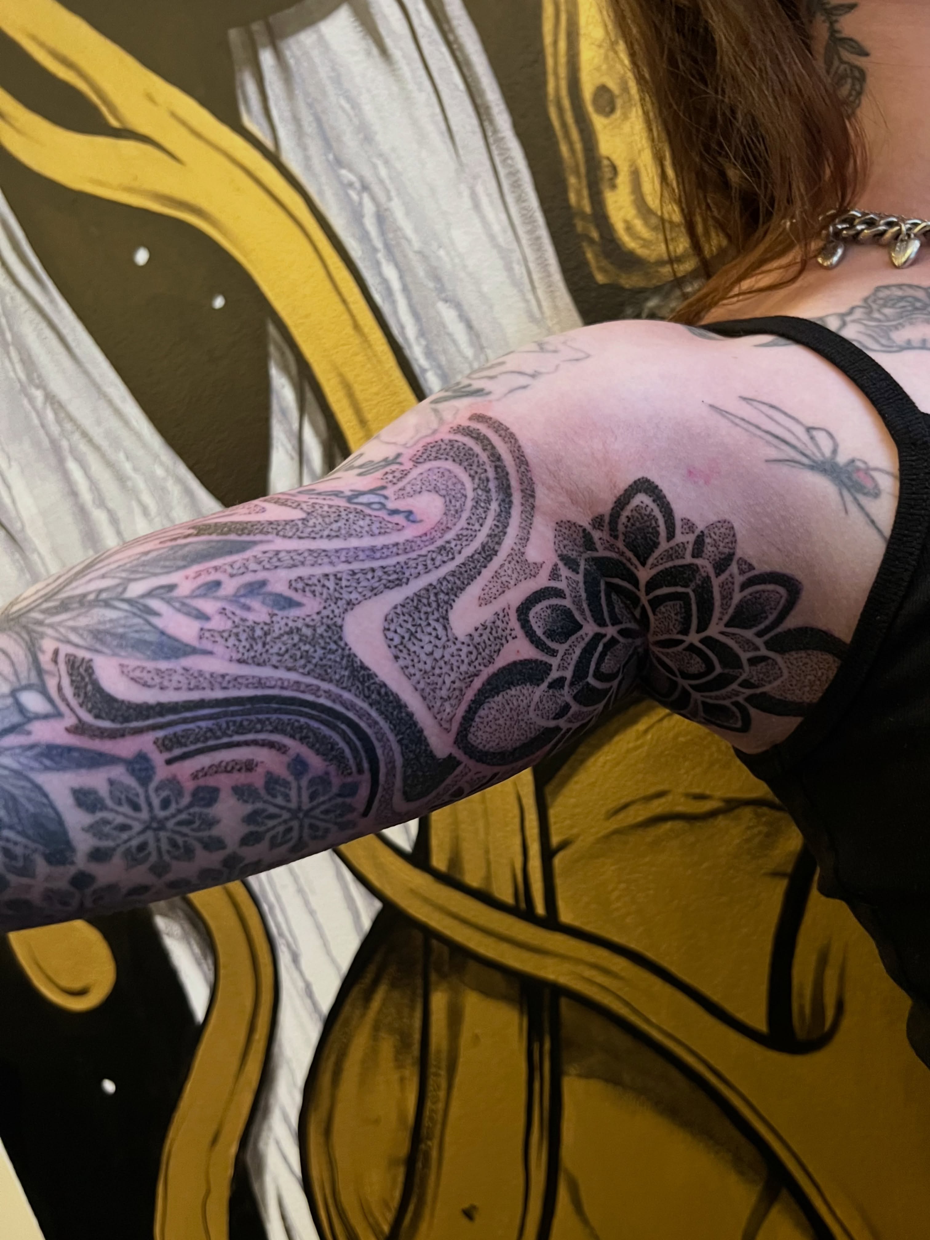 Lotus flower dotwork tattoo on the upper arm by Riley