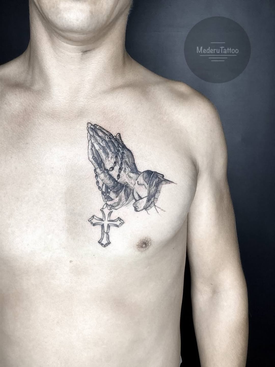Praying hands with rosary and cross Chicano tattoo on the chest by Alexey Molyarenko