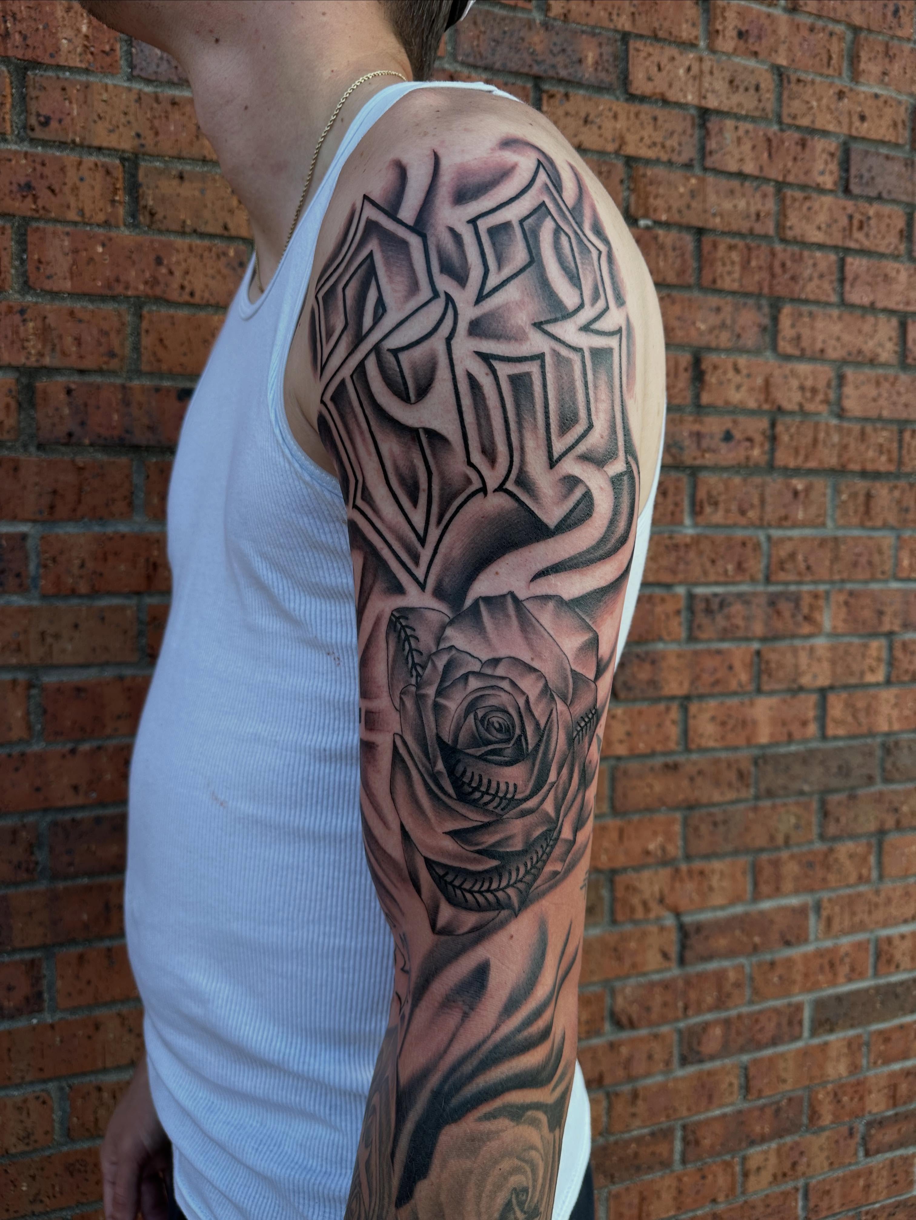 Rose and skull geometric tattoo on the upper arm by DFW