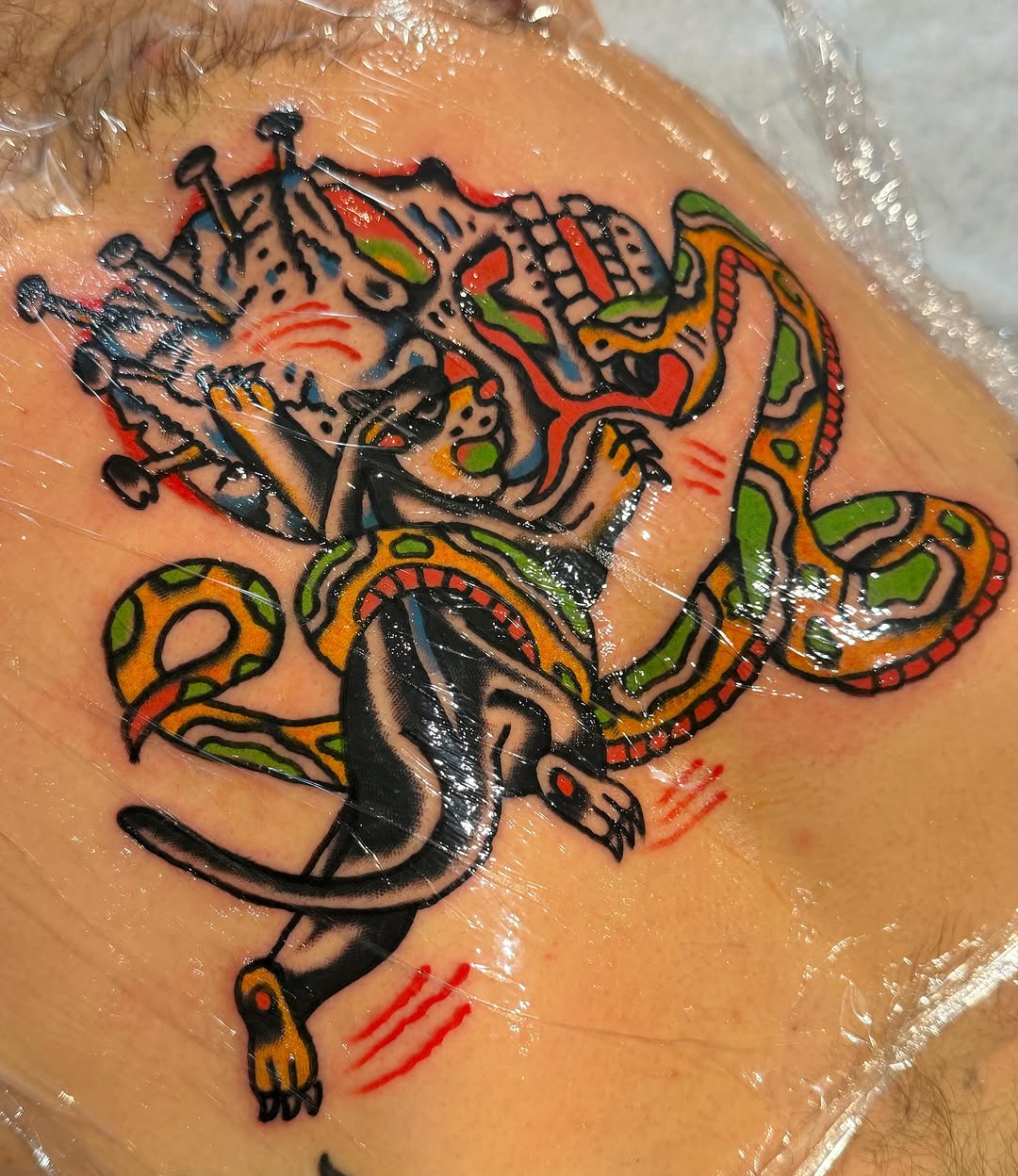 Snake and mask American traditional tattoo on the torso by Jake
