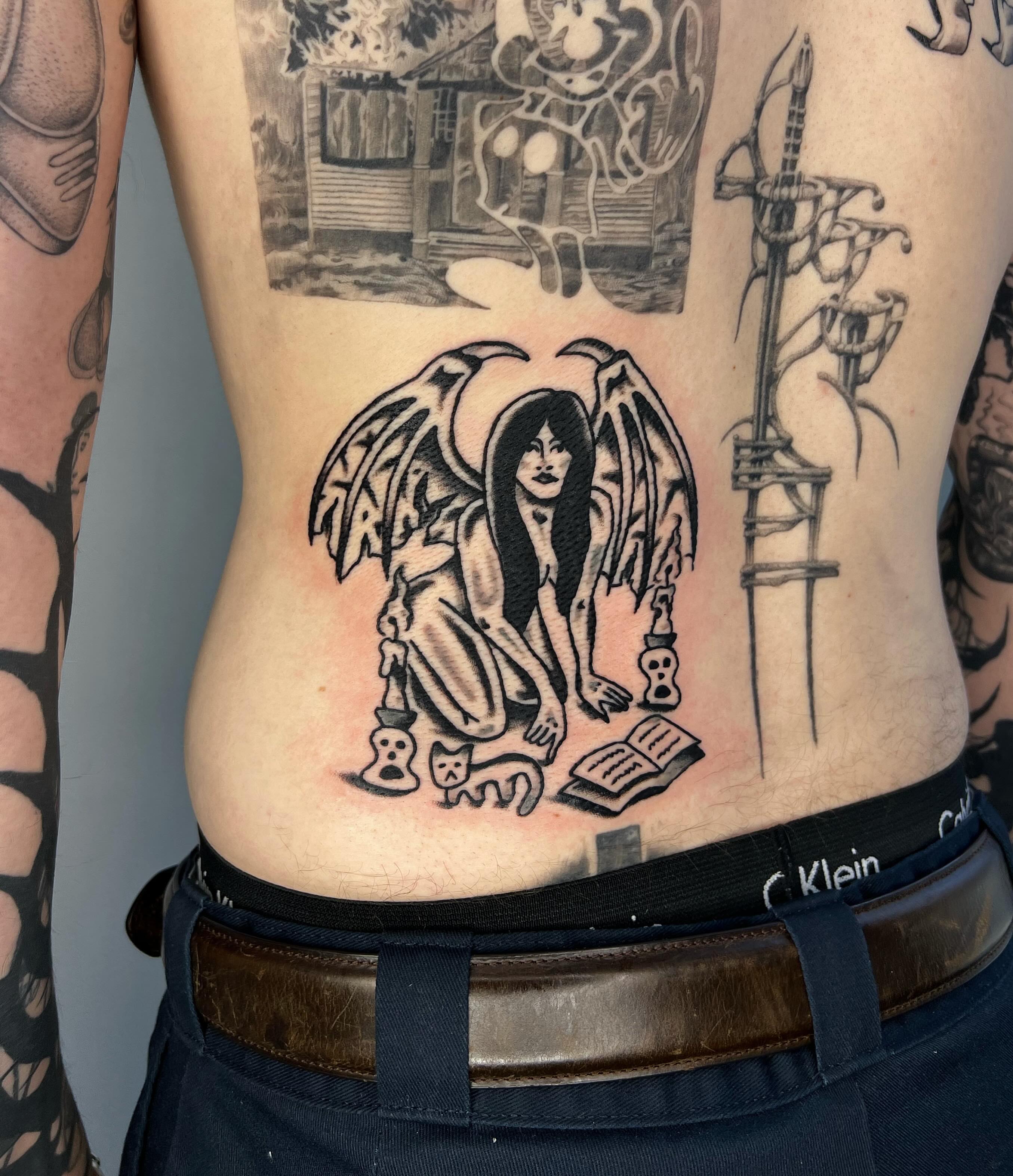 Angel with book black and grey tattoo on the torso by Jake