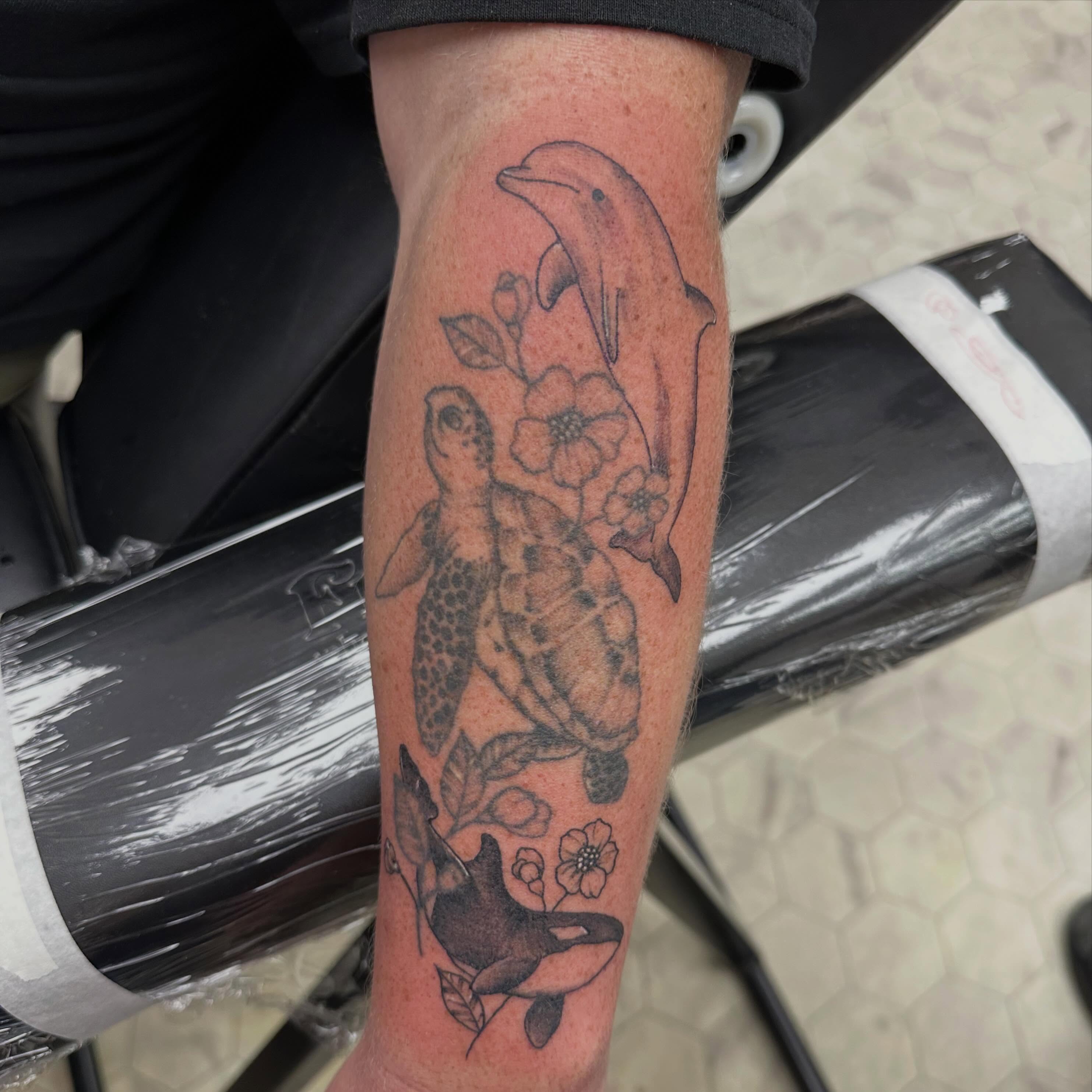 Sea creatures and flowers black and grey tattoo on the forearm by Nicki Hoverson