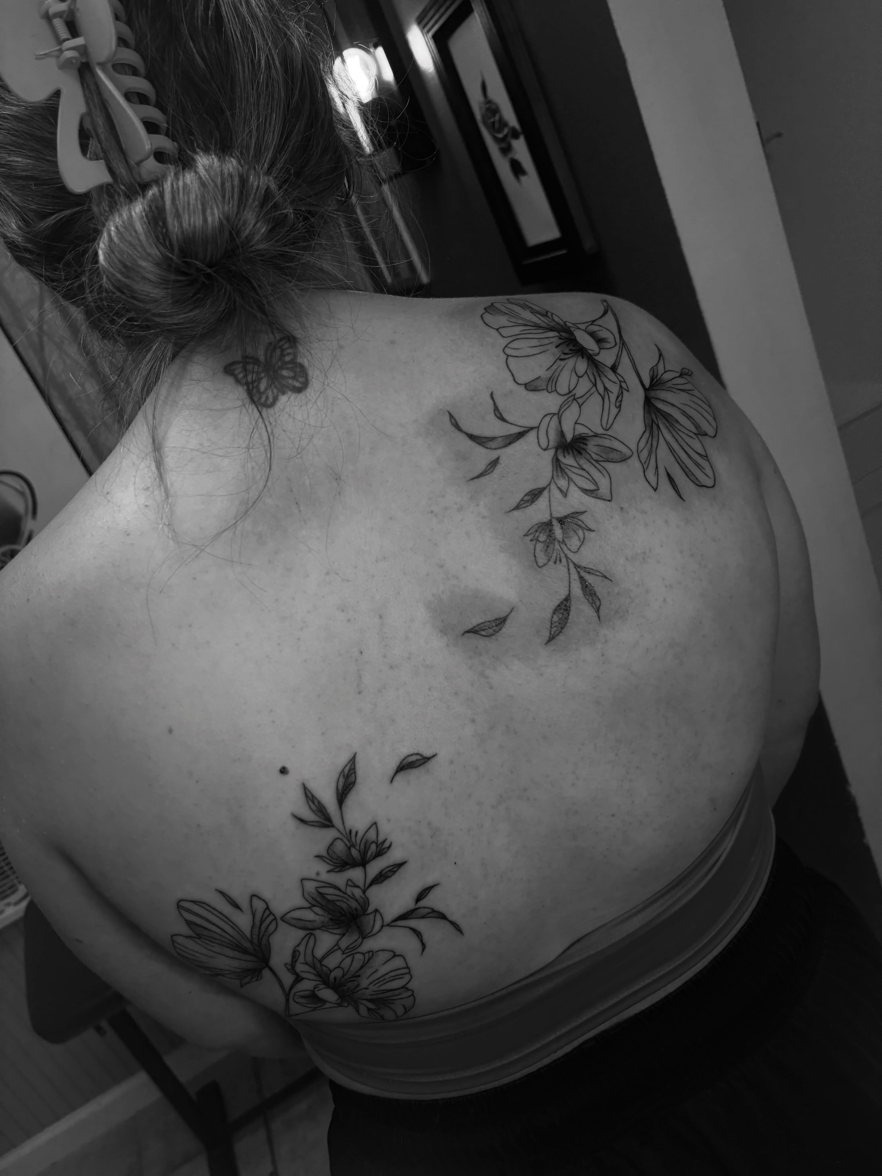 Flowers and butterfly black and grey tattoo on the back by ⋆.˚ ☾ .⭒˚ alaina