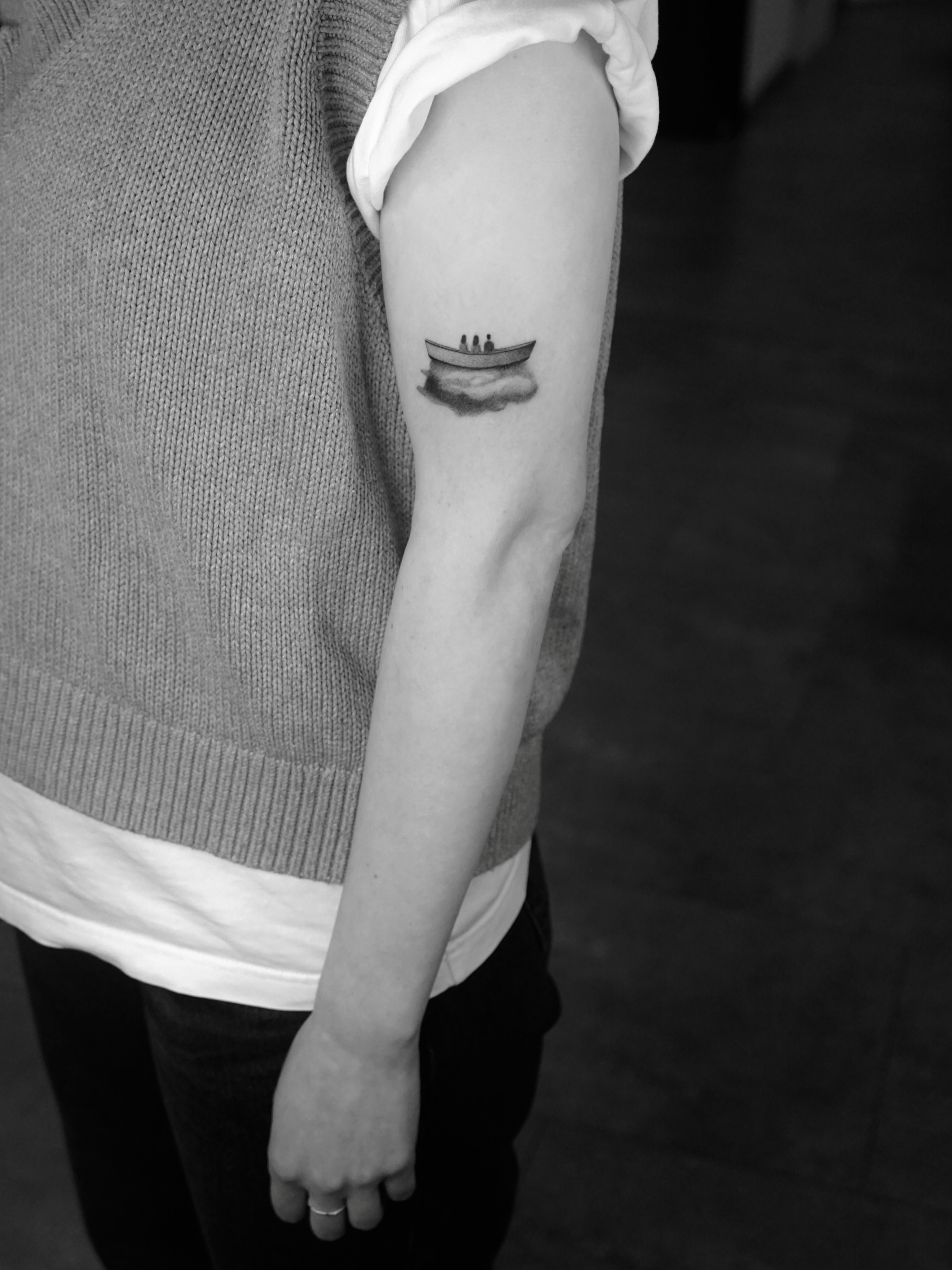 Boat with figures black and grey tattoo on the forearm by Metin Karaatli