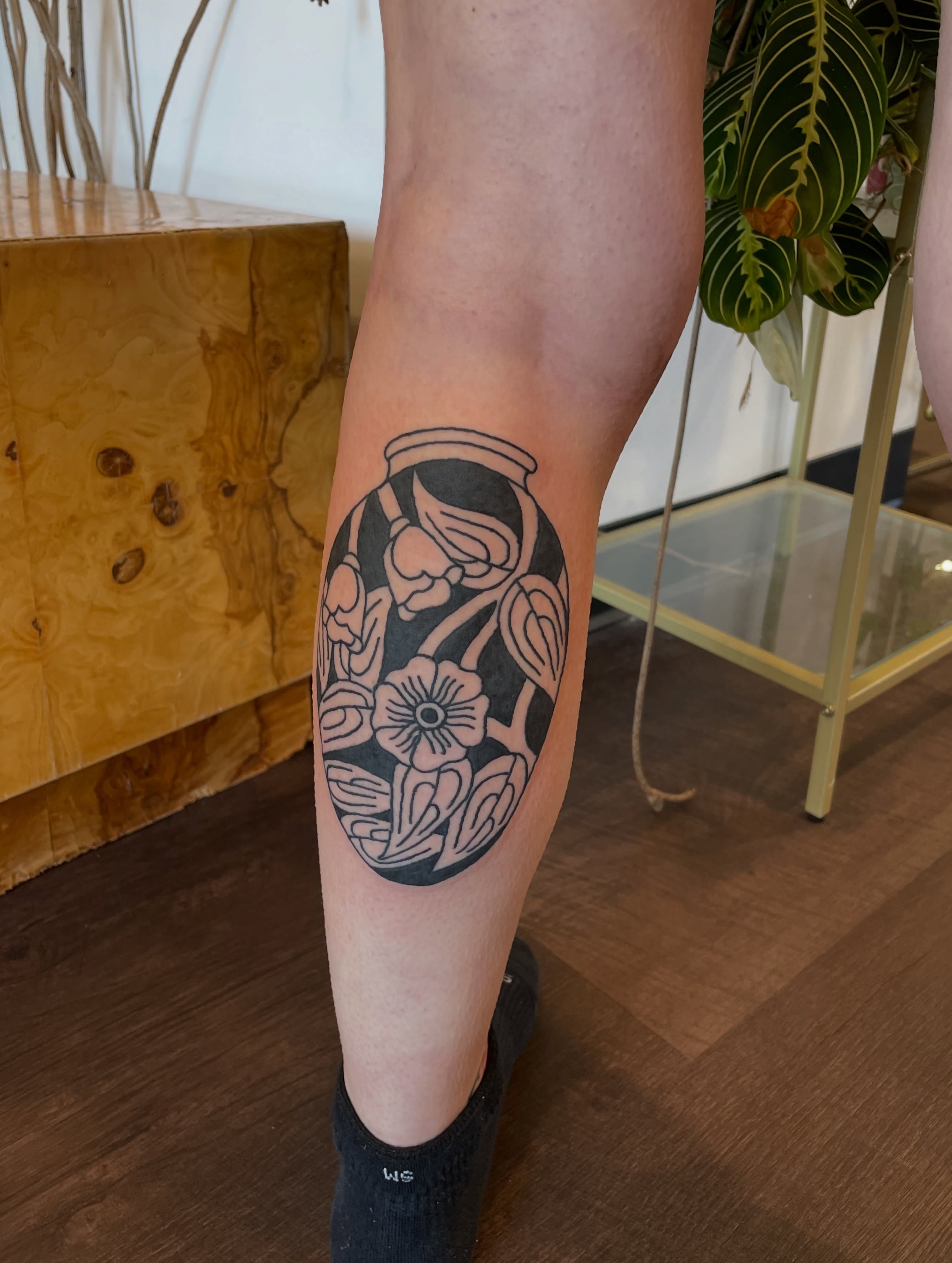 Jar with floral design black and grey tattoo on the forearm by @pizzabref