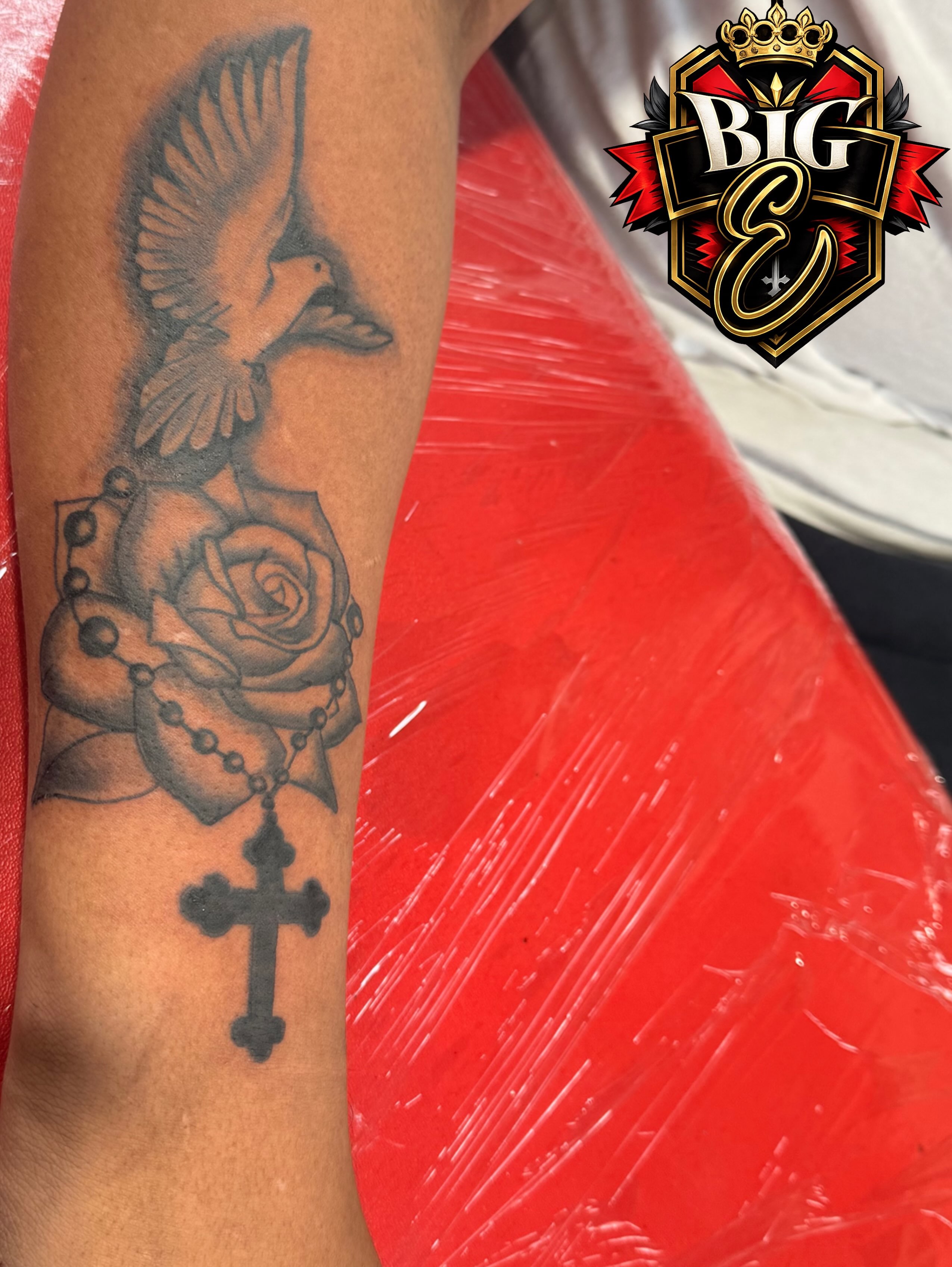Dove, rose, cross black and grey tattoo on the forearm by Jones Eric