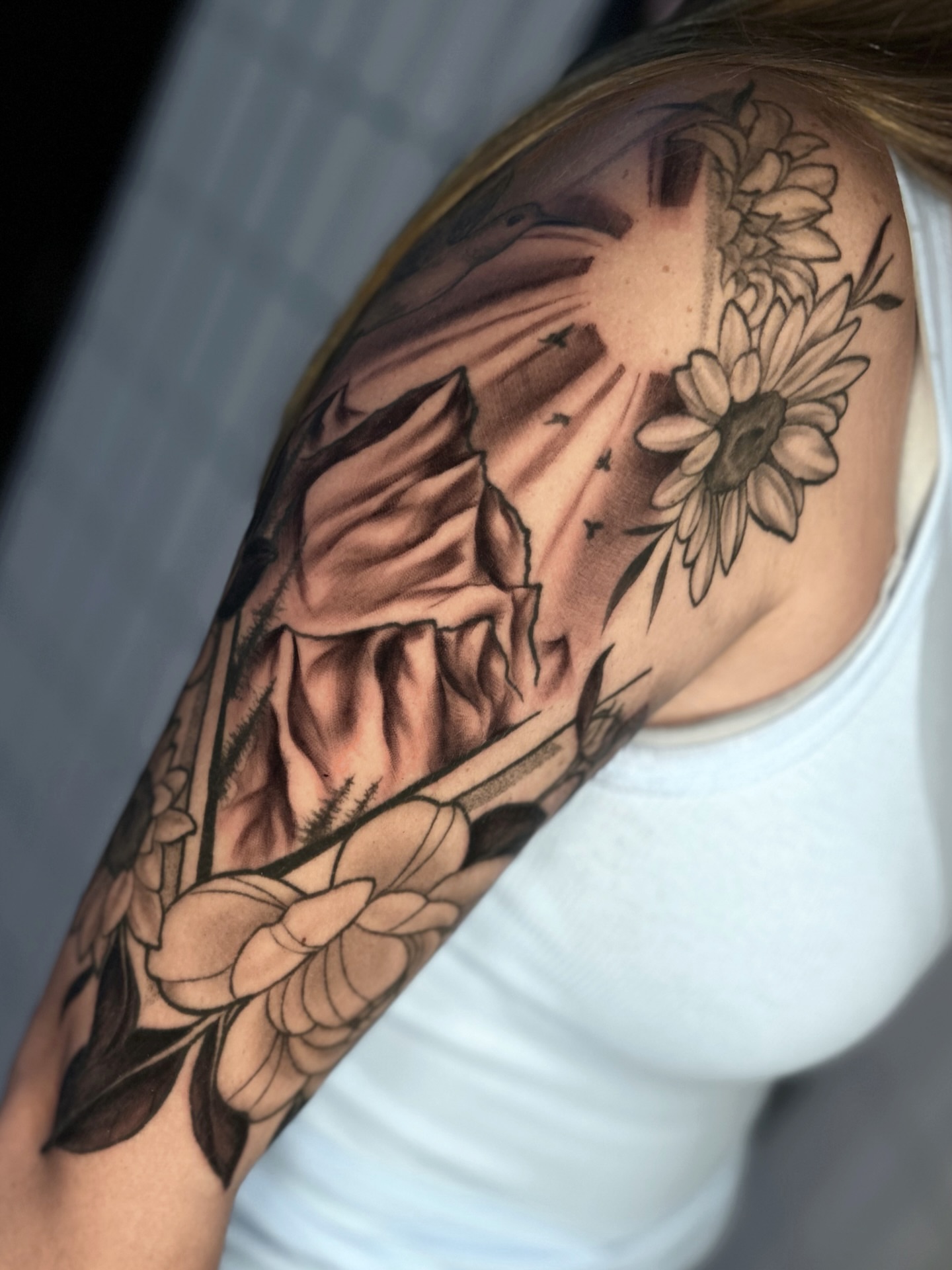 Sunflower and floral landscape realism tattoo on the shoulder by πΈππππππ π½ππππππππ