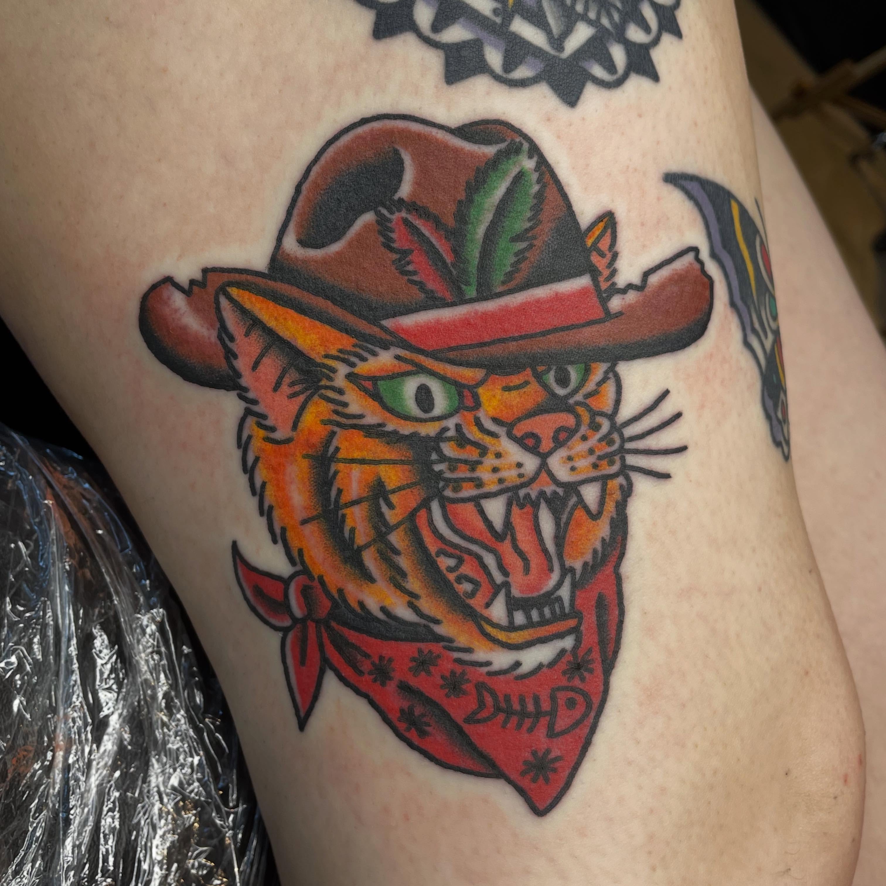Cat wearing cowboy hat American traditional tattoo on the thigh by Mitchell Willard