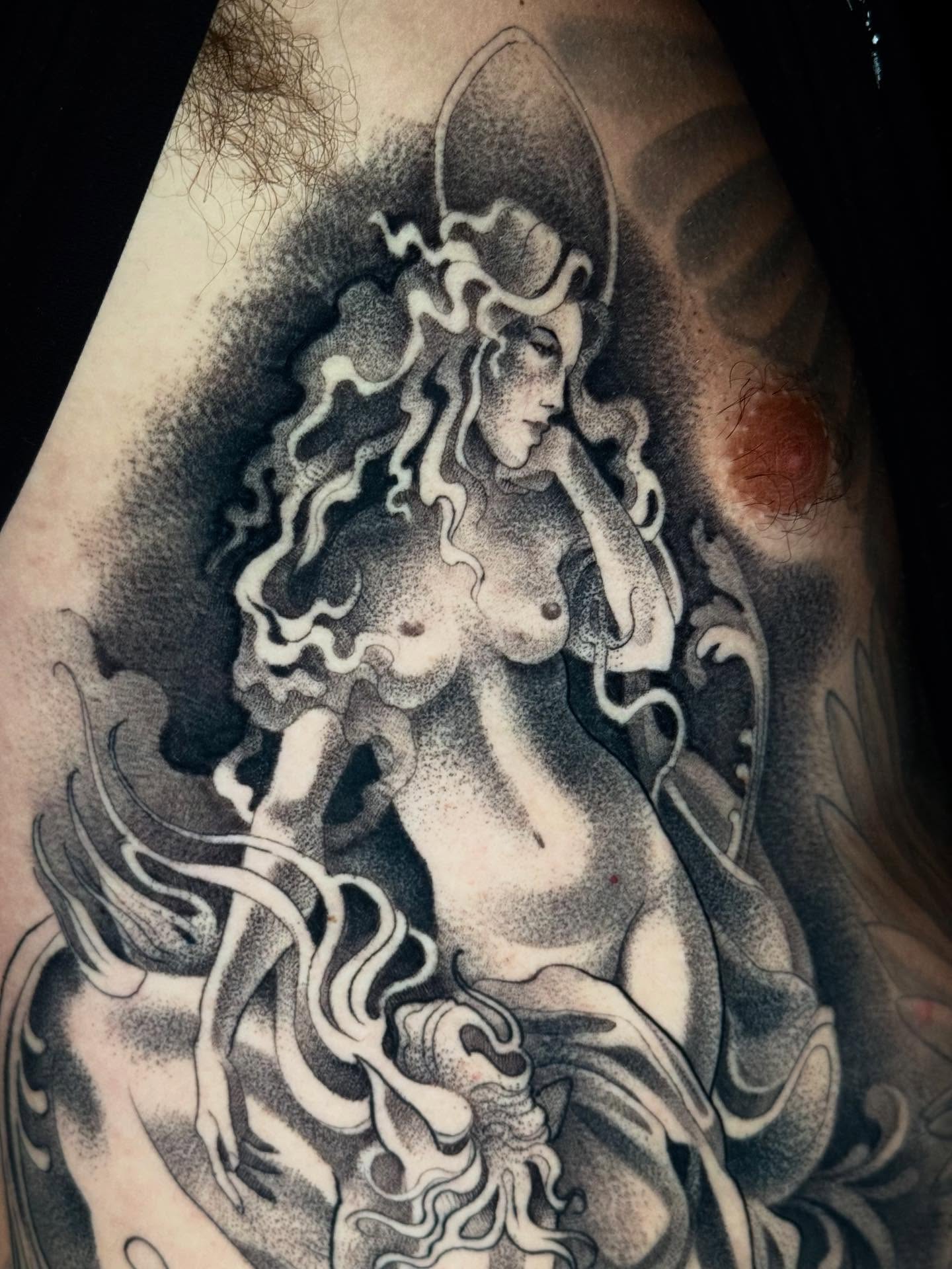 Nude woman with flowing hair dotwork tattoo on the thigh by Mads Ink