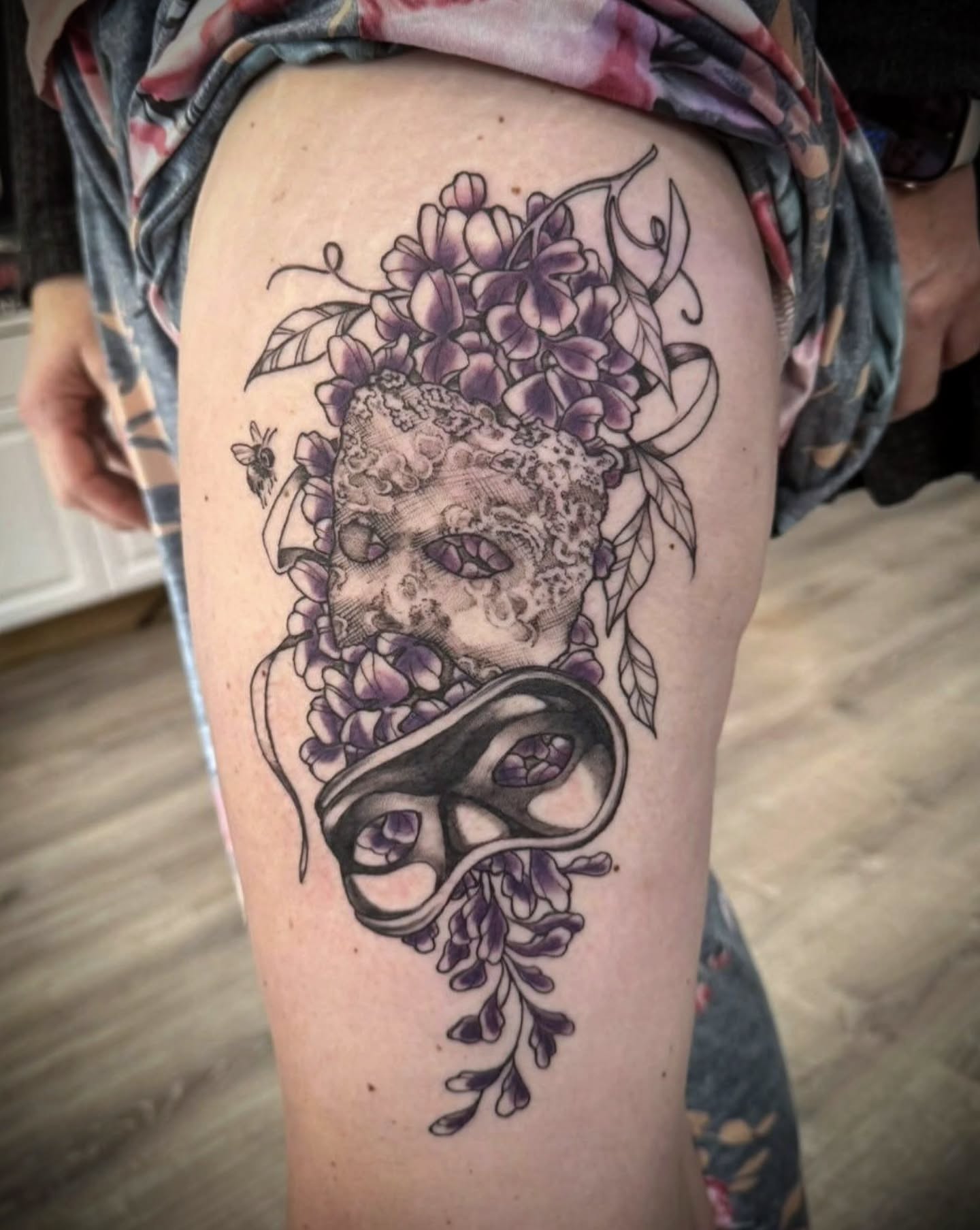 Mask and flowers realism tattoo on the thigh by Tricky Lake, Newfield, New Jersey