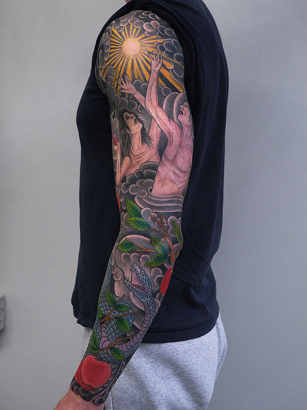 Serpent and apple American traditional tattoo on the upper arm by Erick Lynch, Cambridge, Massachusetts