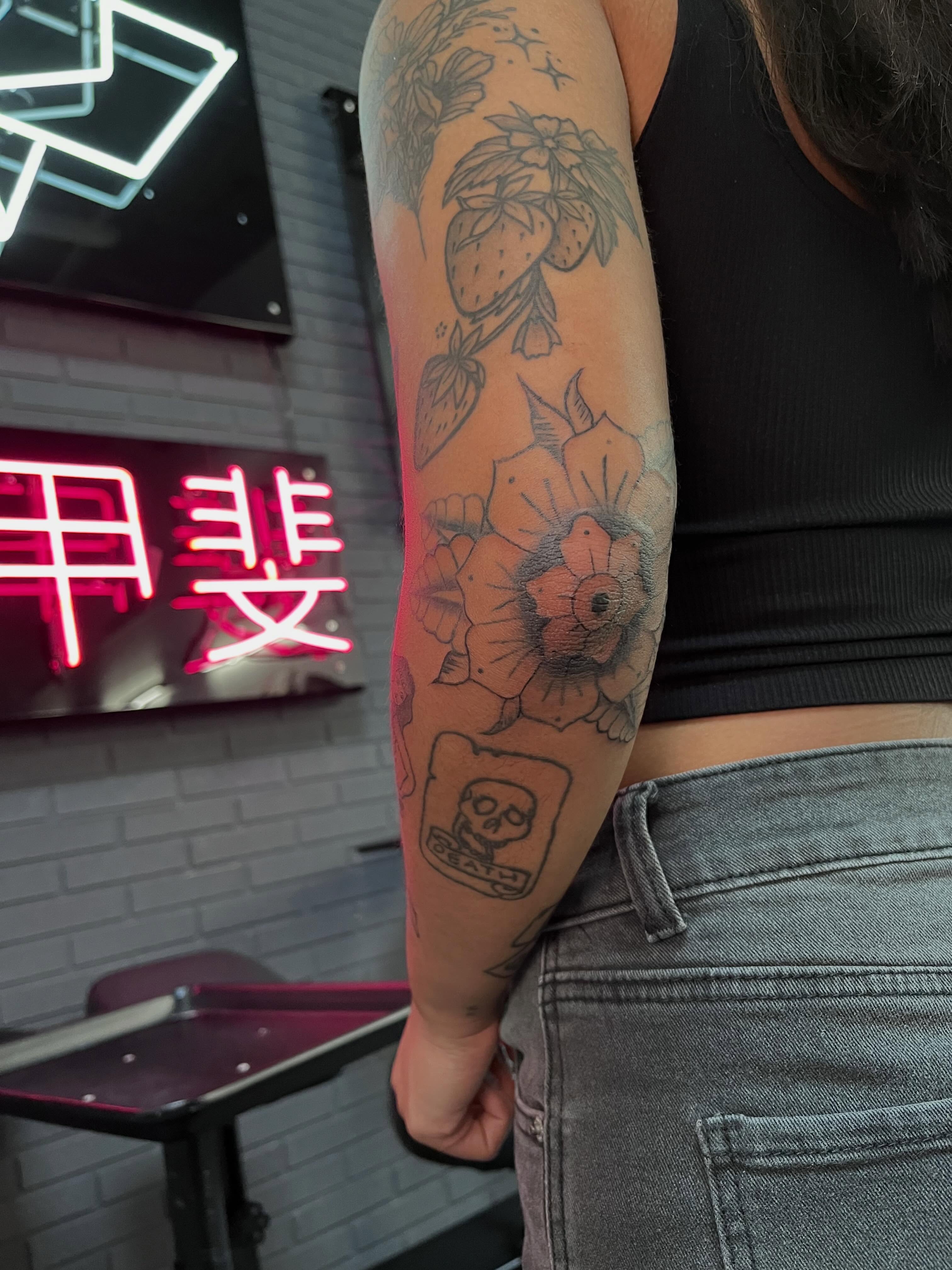 Flowers and strawberries black and grey tattoo on the forearm by Bunny 🐰