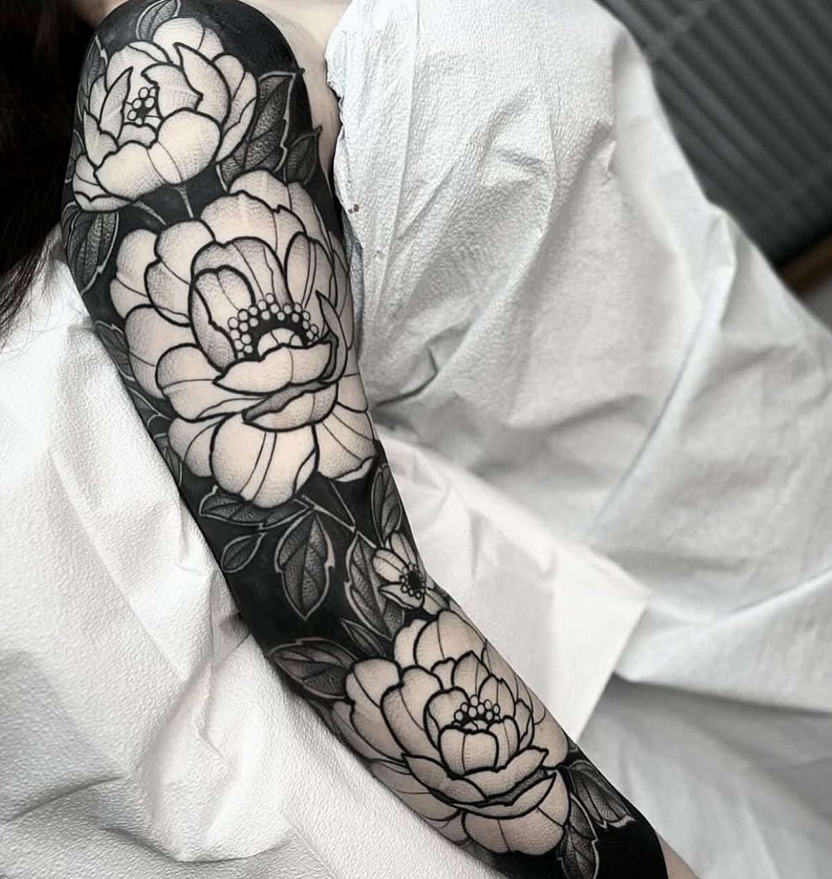 Floral sleeve black and grey tattoo on the upper arm by Luna Lucero