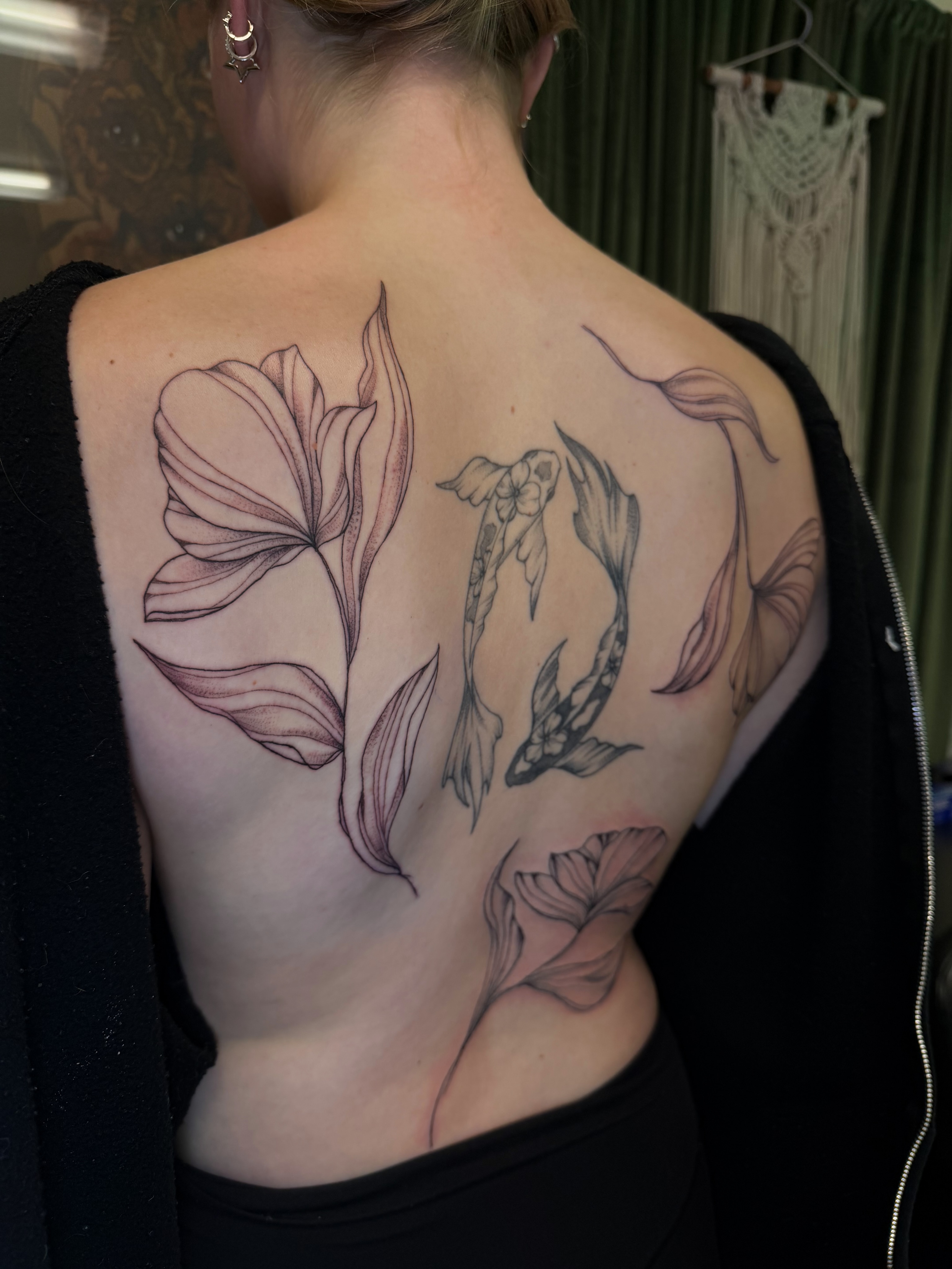 Flower and fish realism tattoo on the back by McKenna
