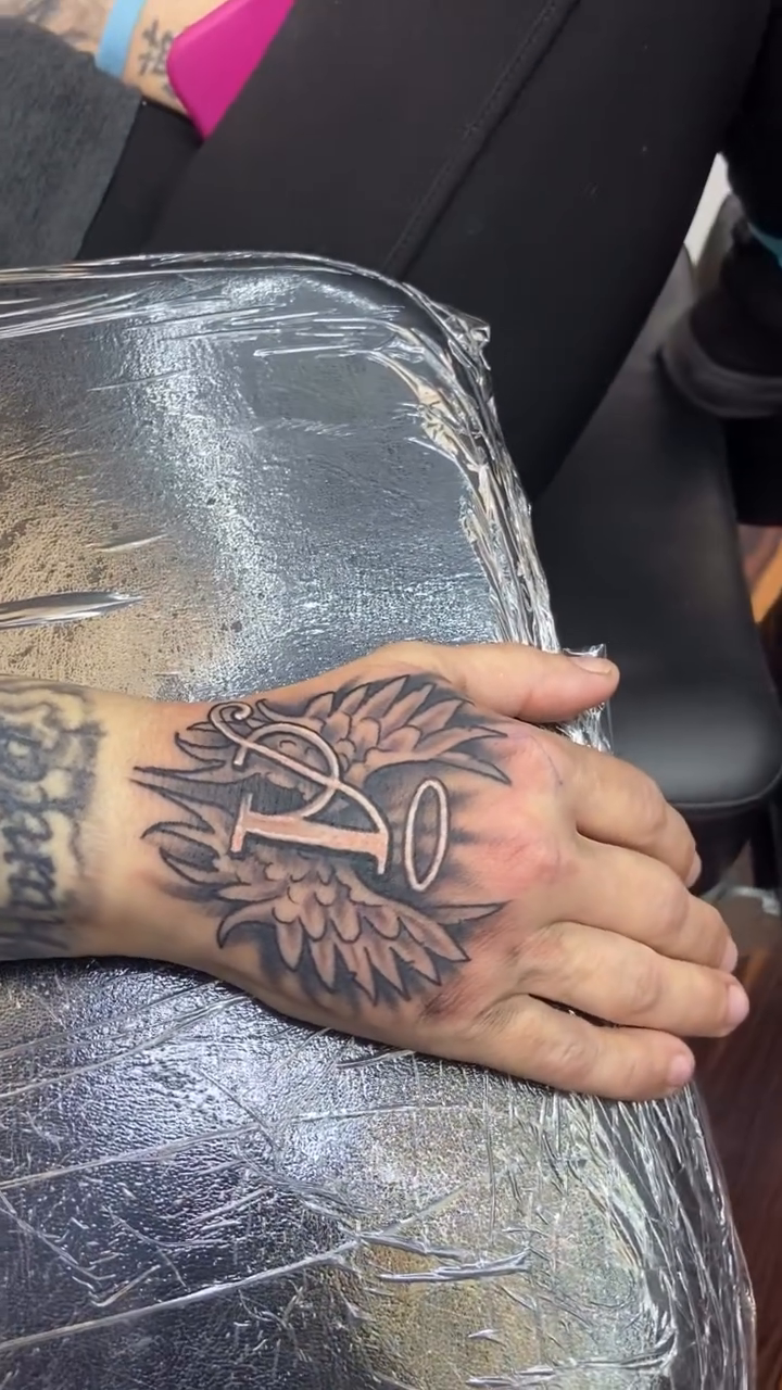 Letter I with wings and halo Chicano tattoo on the forearm by Sam Hearnen, Lawrence, Kansas