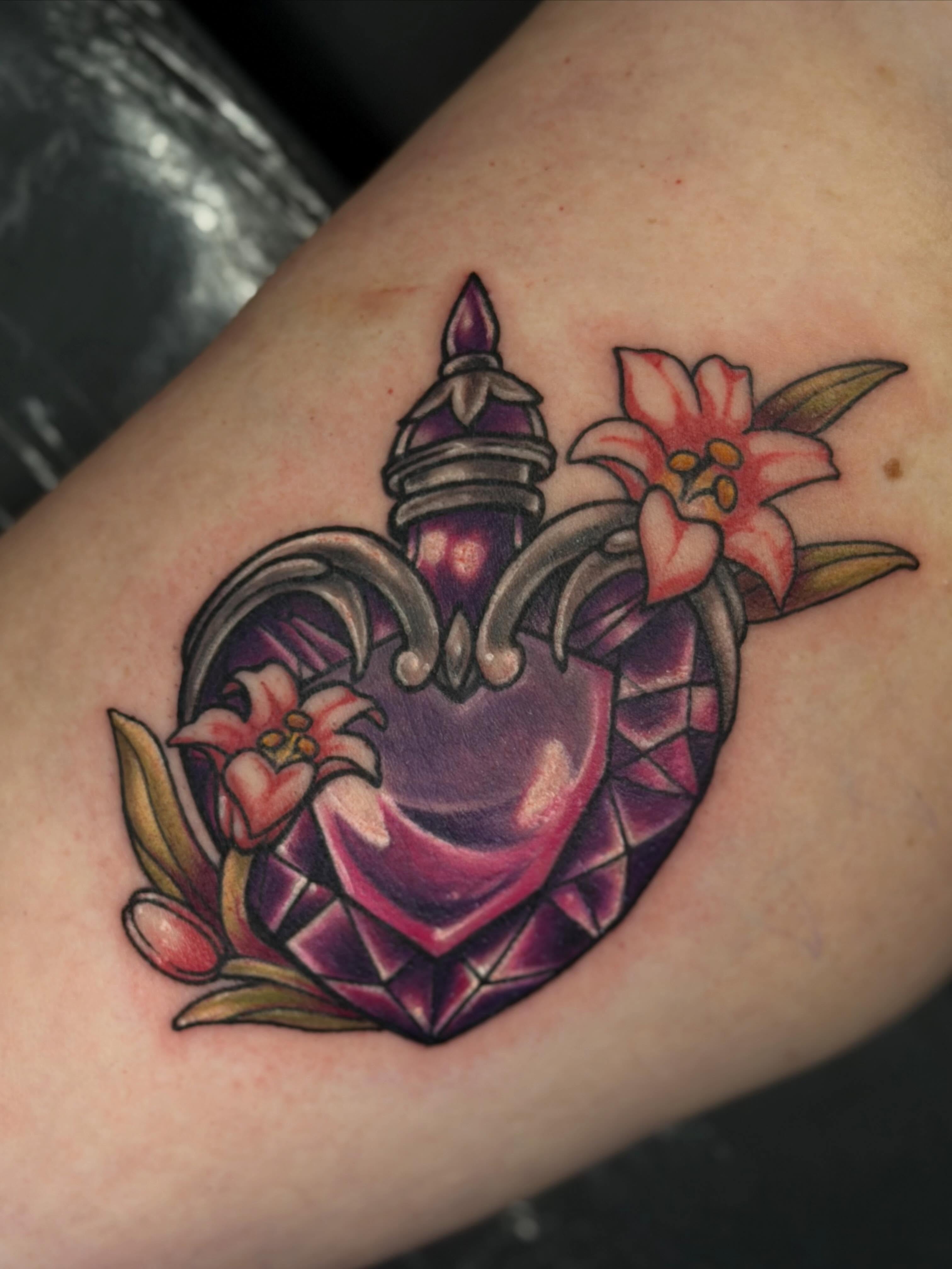 Heart with lilies American traditional tattoo on the forearm by Trista Bettfreund (Birdy)