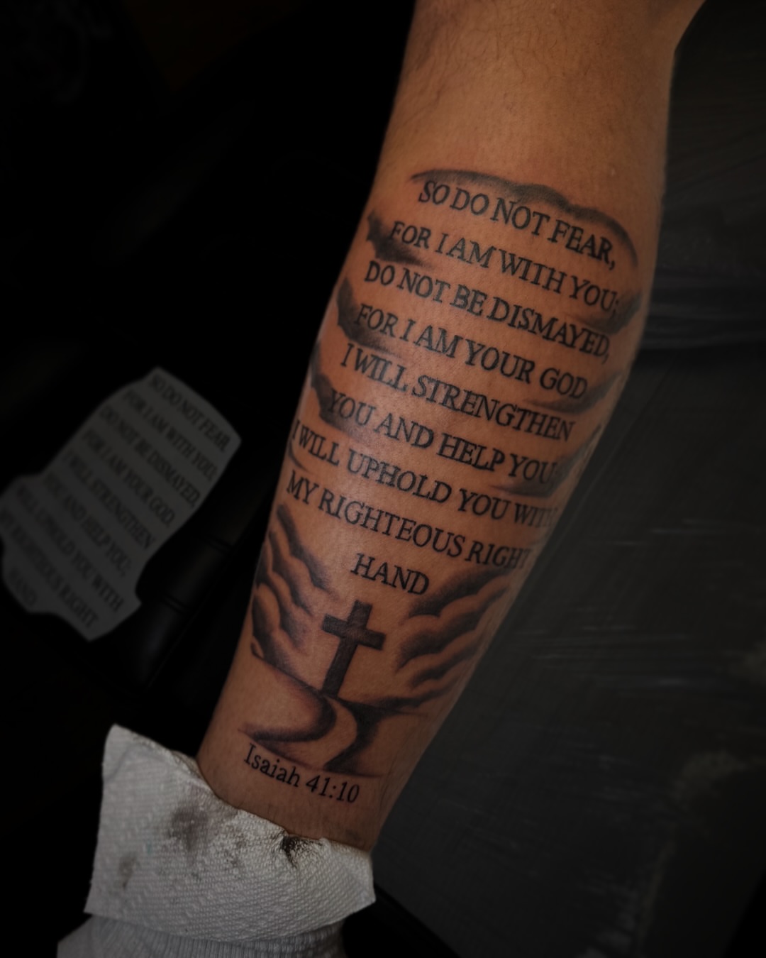 Religious verse black and grey tattoo on the forearm by Juan Pablo