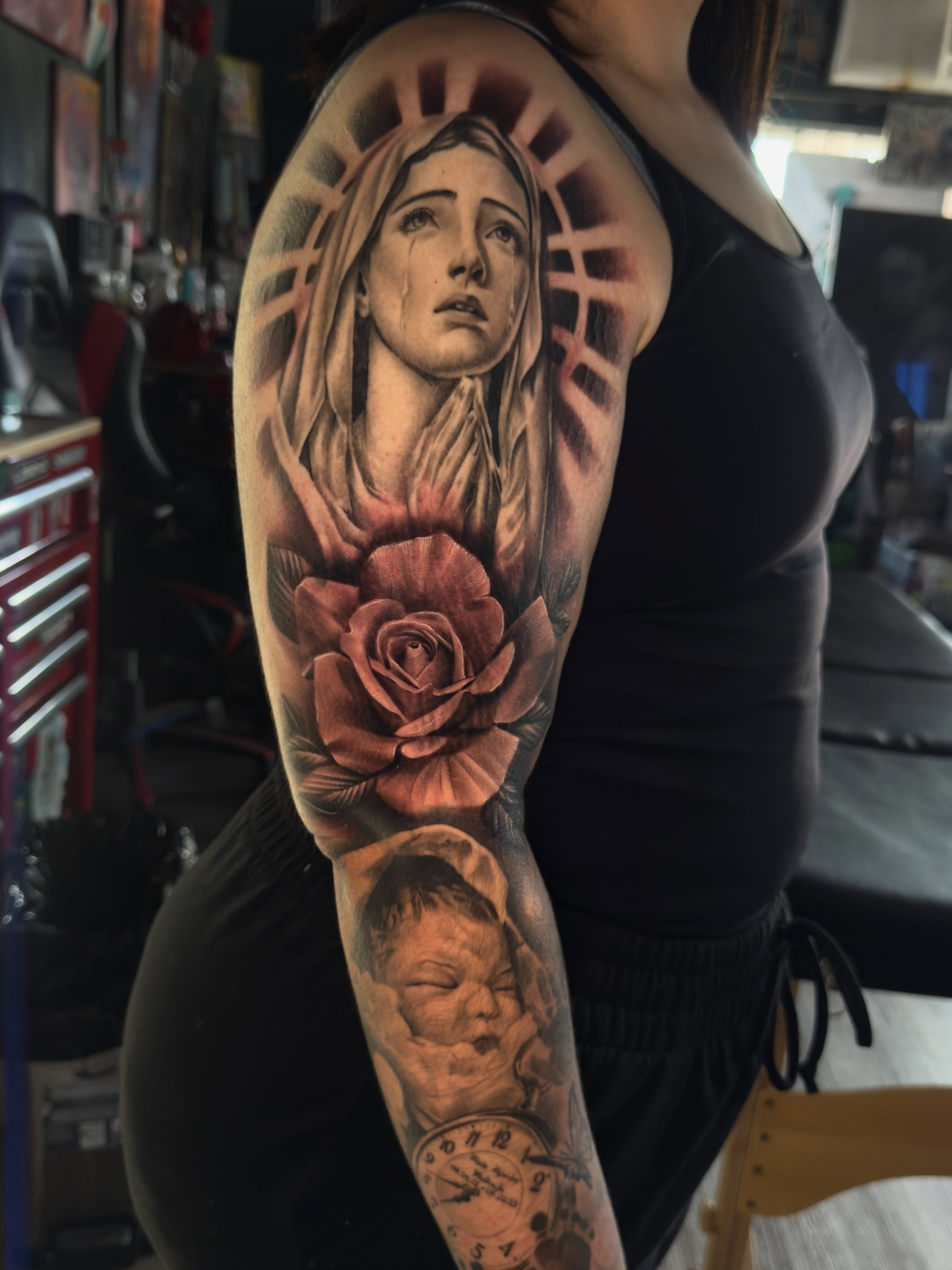 Religious figure with rose realism tattoo on the forearm by Dallas tattoo artist, Dallas, Texas