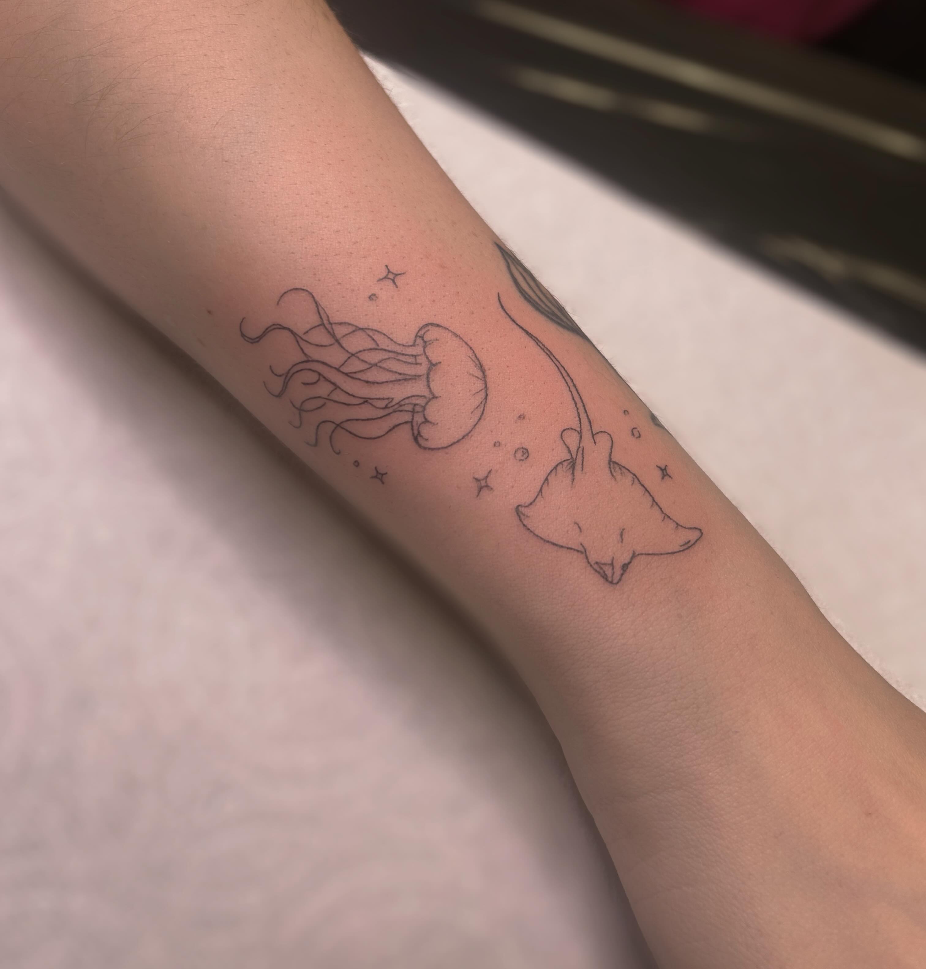 Jellyfish and stingray minimalist tattoo on the forearm by 𝒜𝓇𝓉𝒾𝓈𝓉 𝒟𝒶𝒾𝓈𝓎 ♡