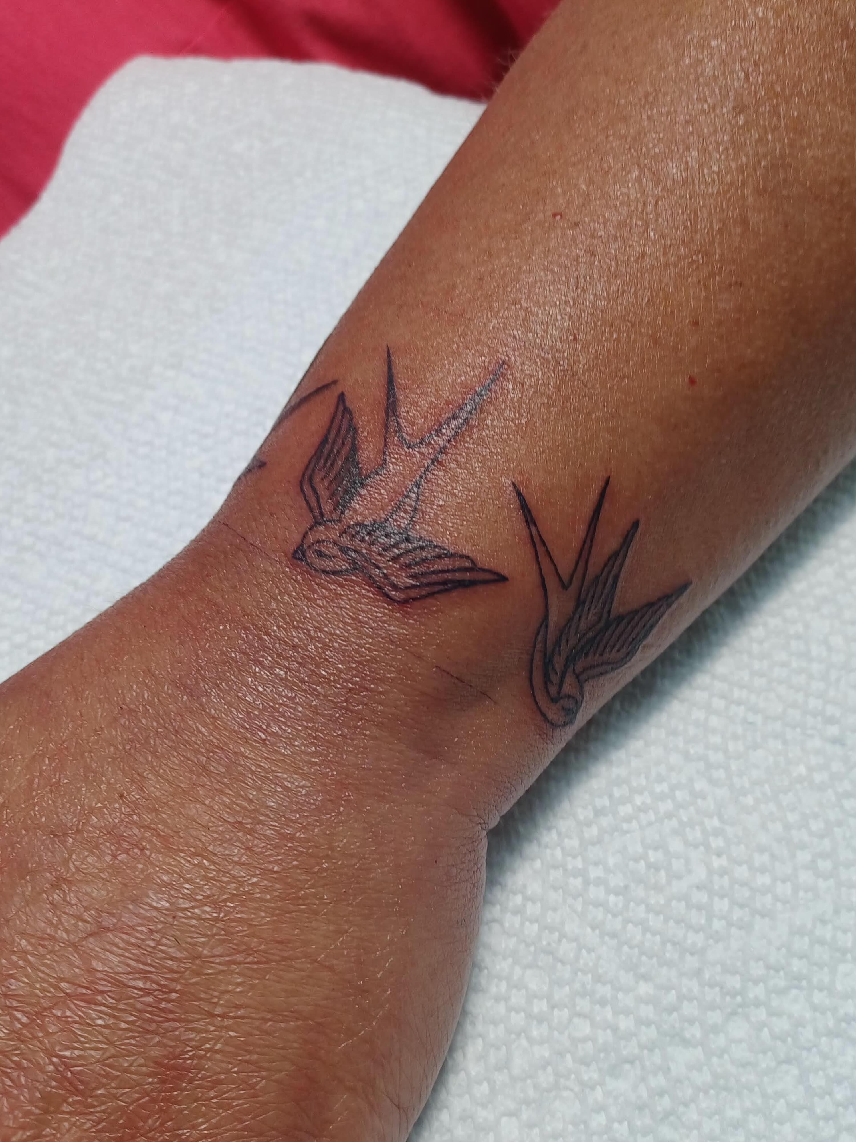 Swallows black and grey tattoo on the forearm by Abi