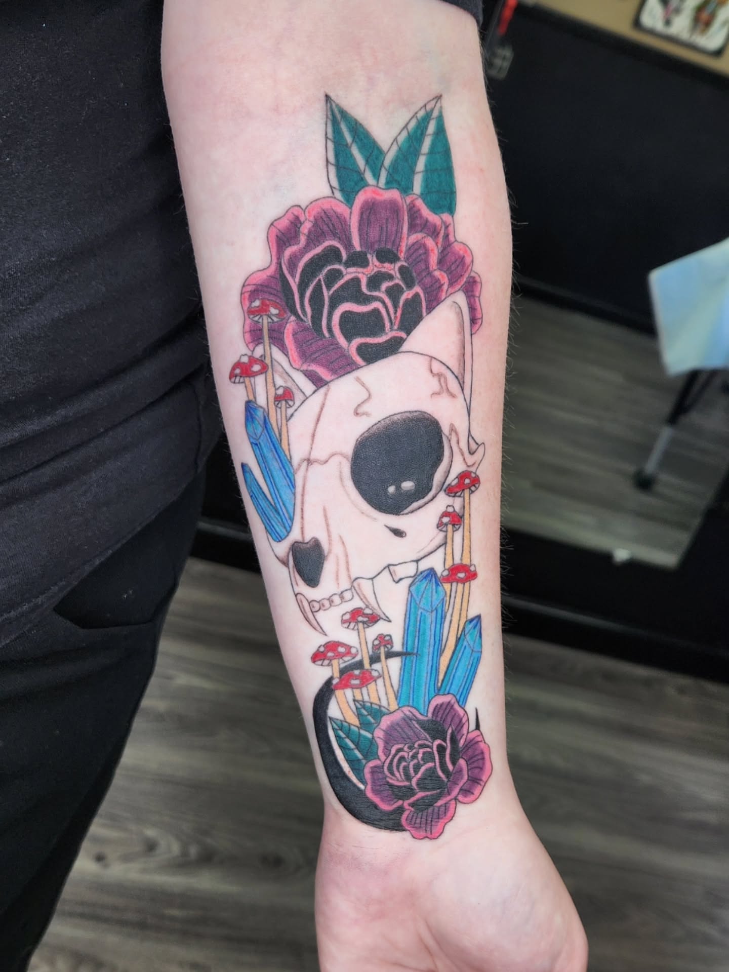 Skull and flowers neo-traditional tattoo on the forearm by Jessica Duggan
