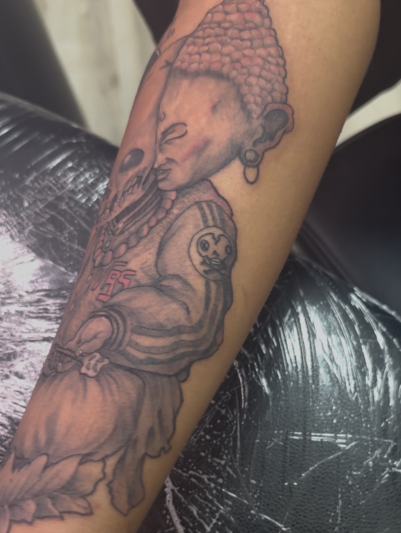 Buddha figure black and grey tattoo on the forearm by Vrs tattoo