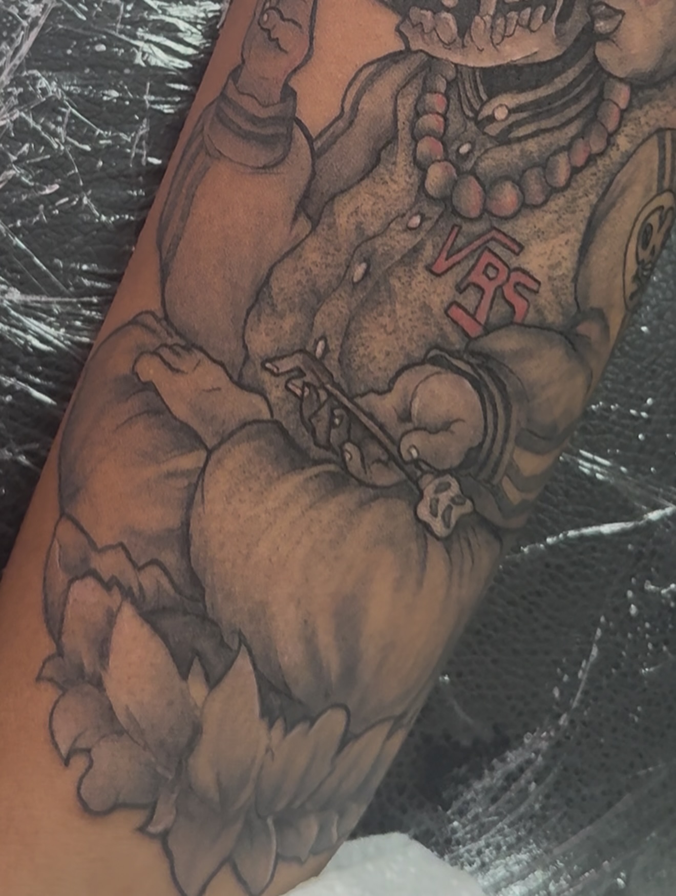 Muscular figure with lotus flower black and grey tattoo on the forearm by Vrs tattoo