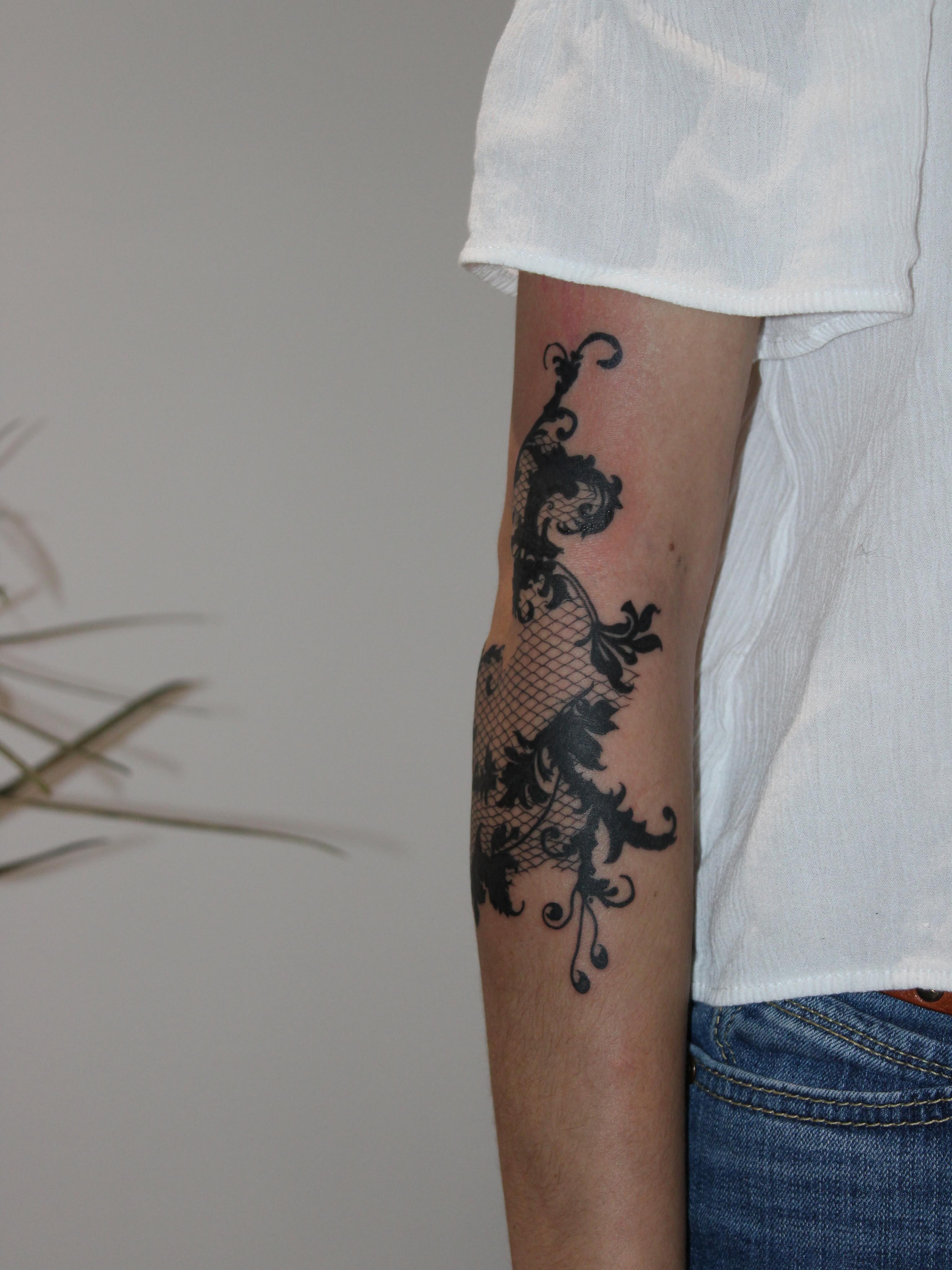 Lace pattern blackwork tattoo on the forearm by Julianna