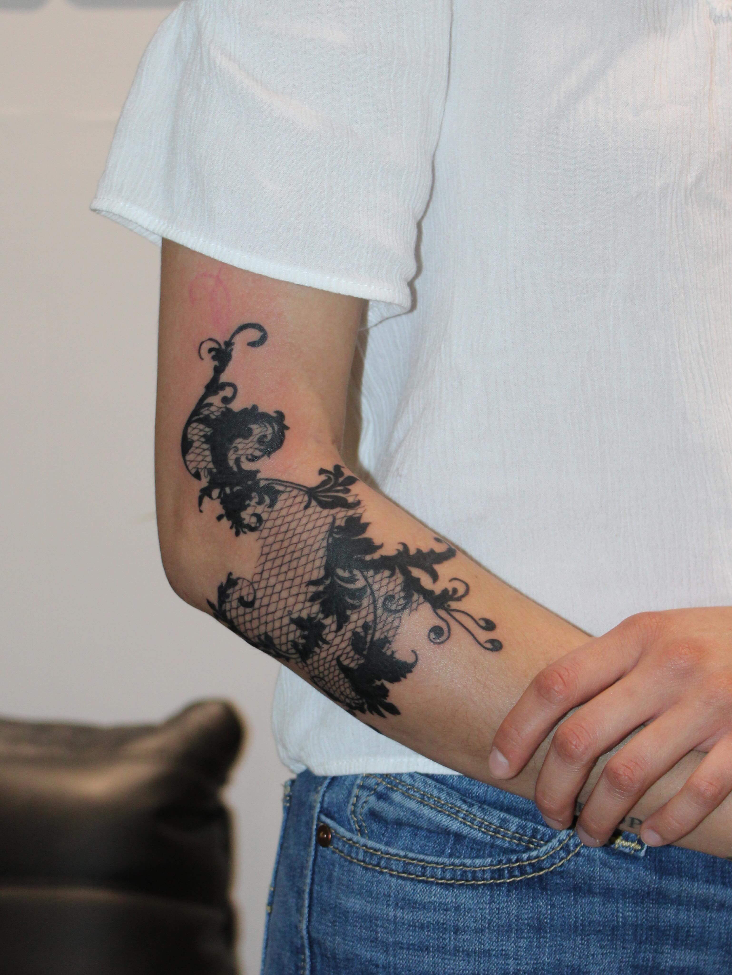 Lace pattern black and grey tattoo on the forearm by Julianna