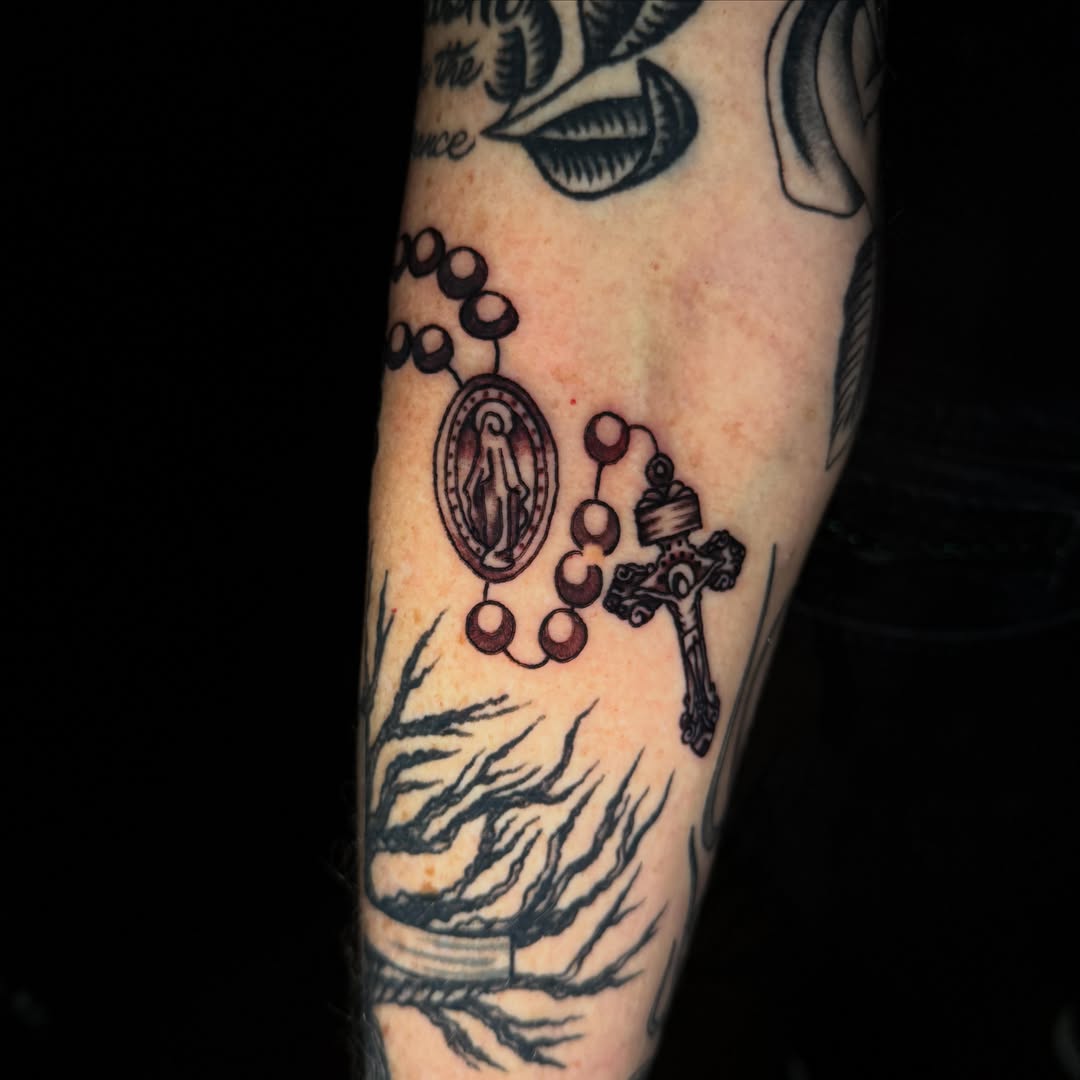 Rosary black and grey tattoo on the forearm by Mallory Brown