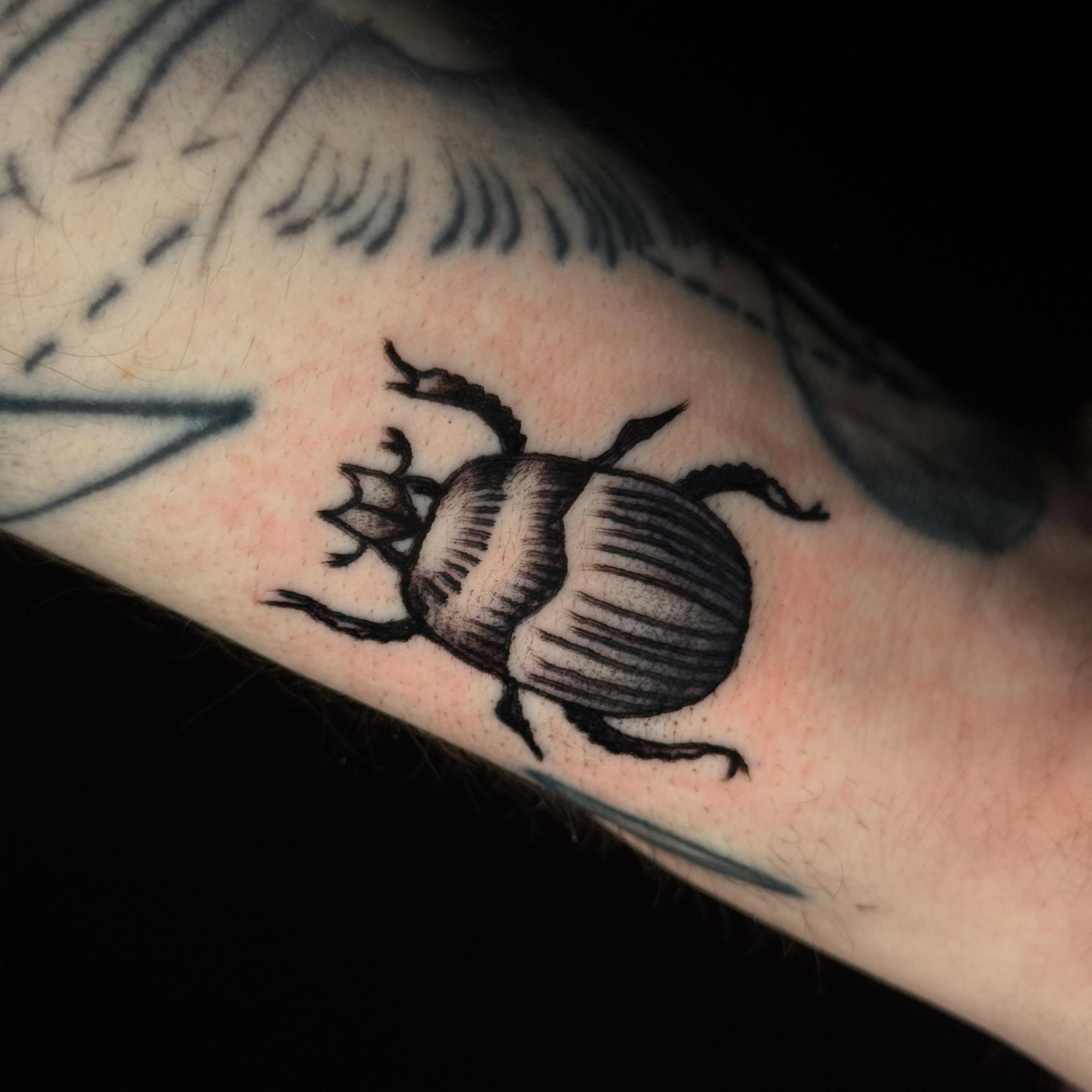 Scarab beetle black and grey tattoo on the forearm by Mallory Brown
