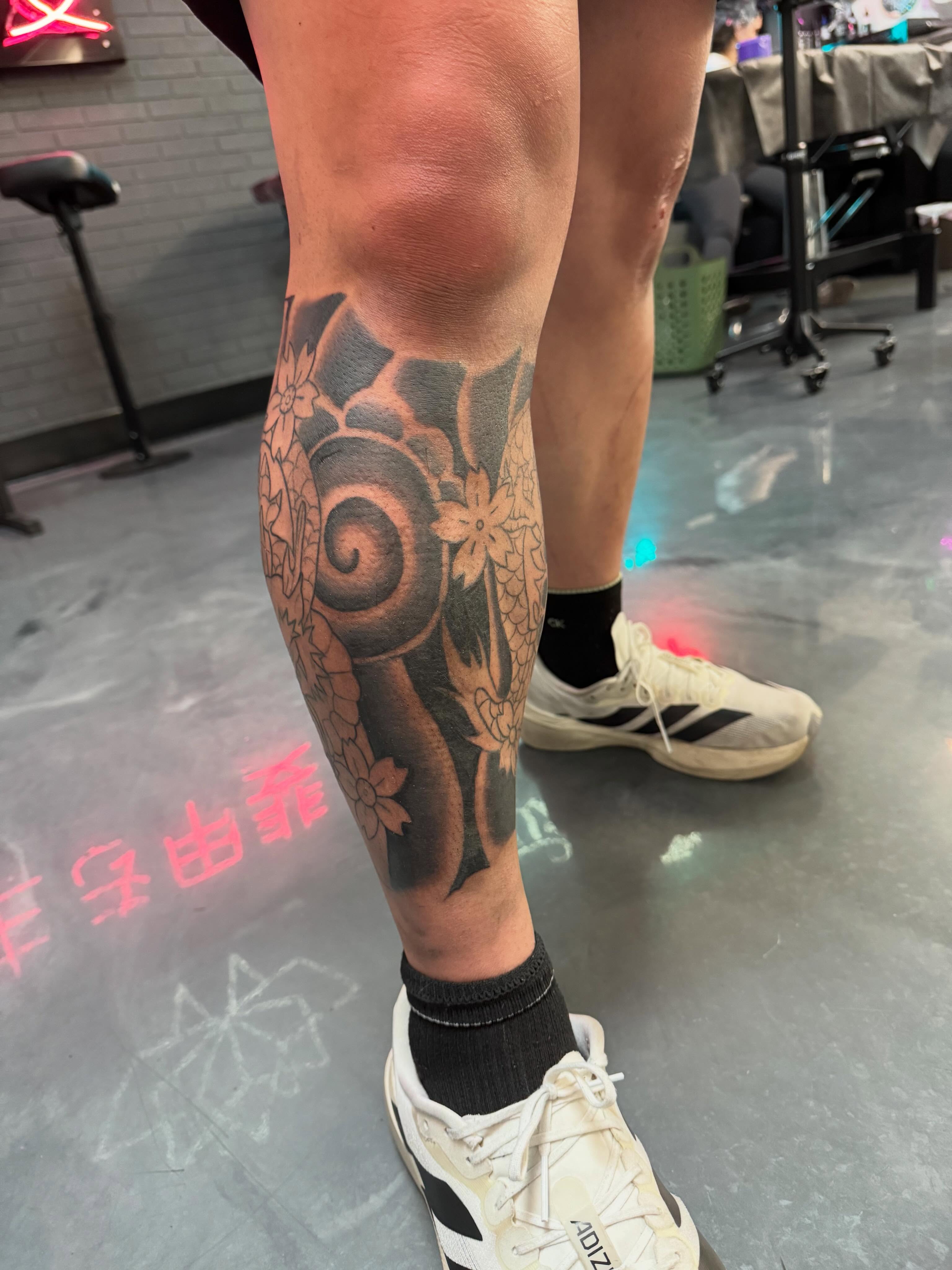 Serpent and flowers black and grey tattoo on the calf by Bunny 🐰