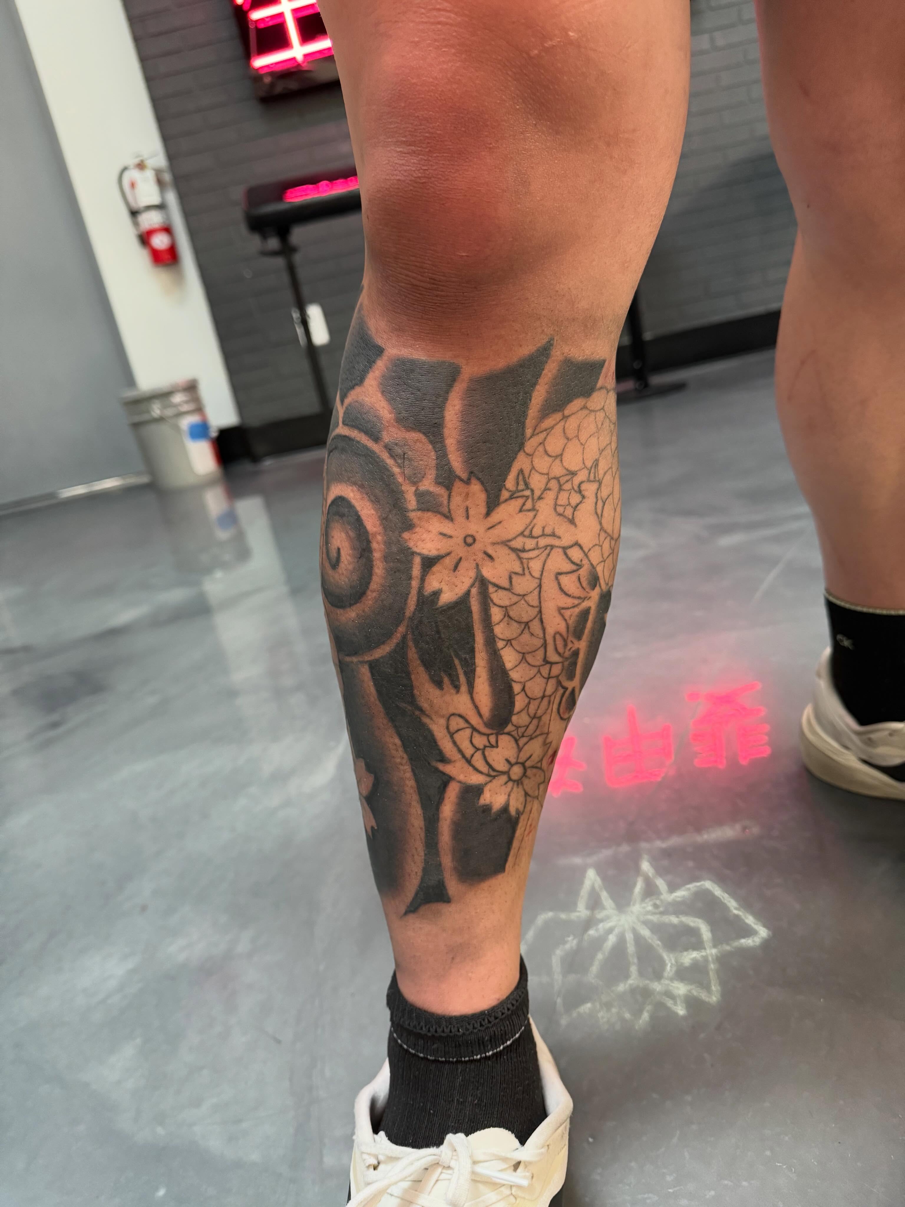 Dragon and flowers black and grey tattoo on the calf by Bunny 🐰