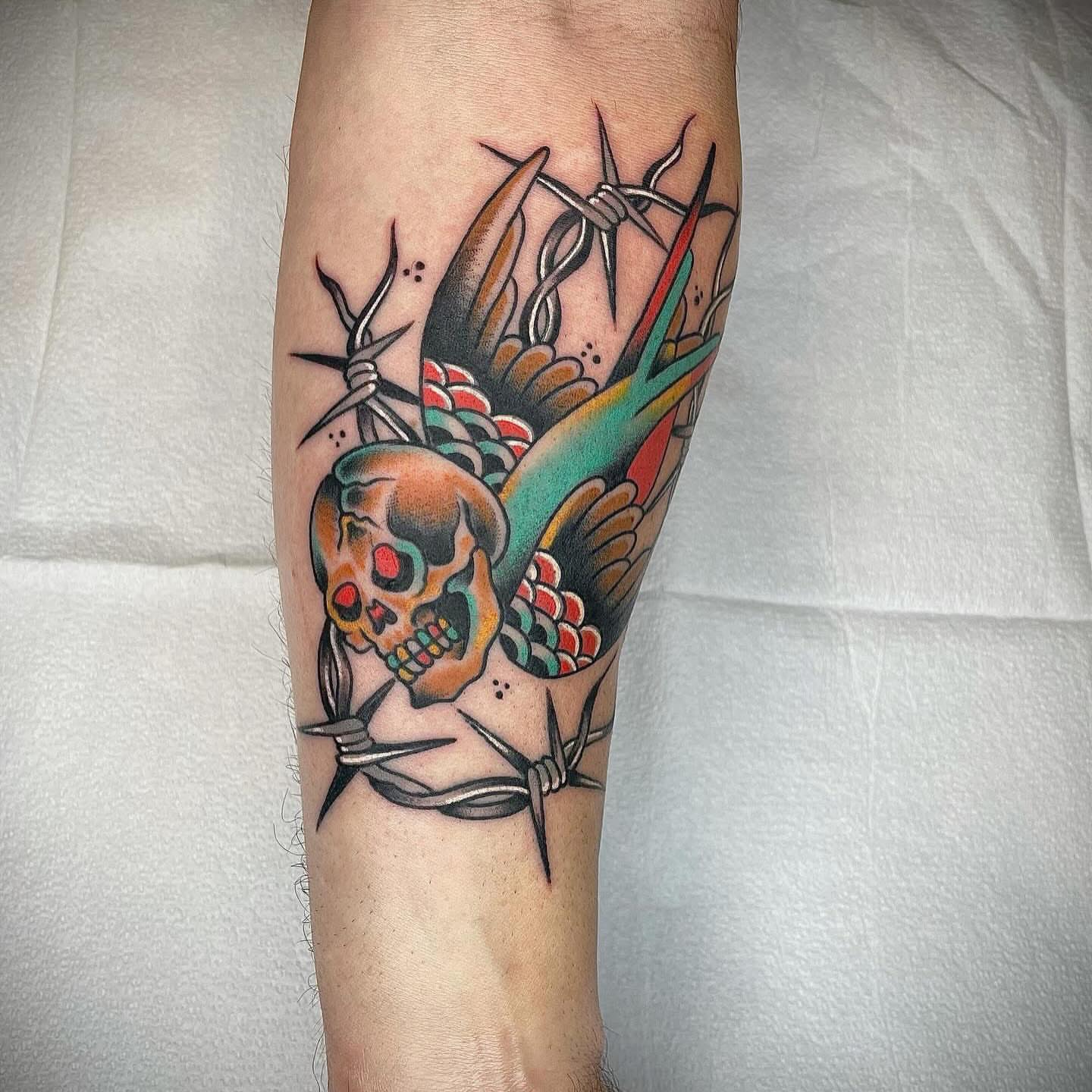 Skull and swallow American traditional tattoo on the forearm by Dave Kruseman