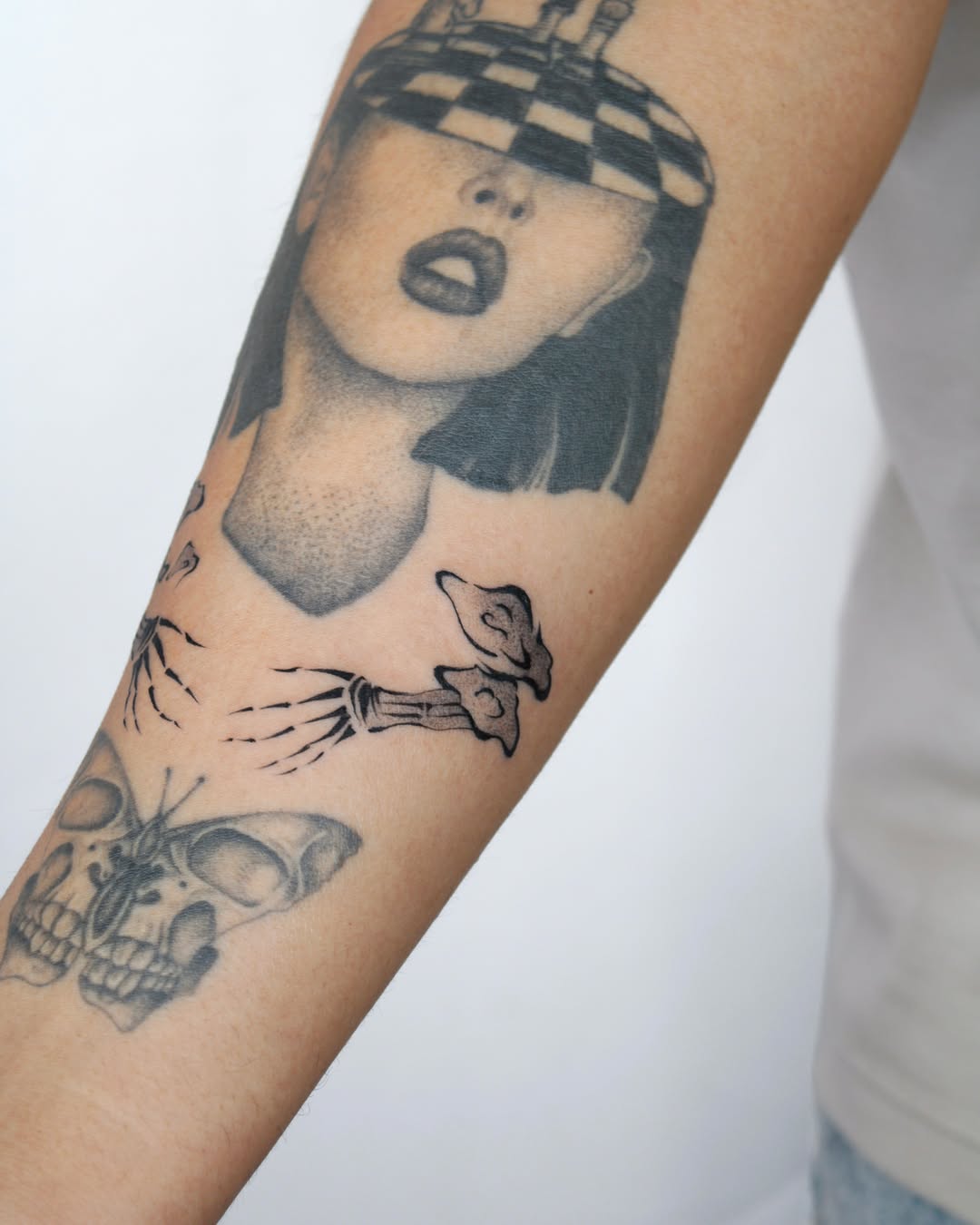 Woman with checkered hat surrealism tattoo on the forearm by Piao