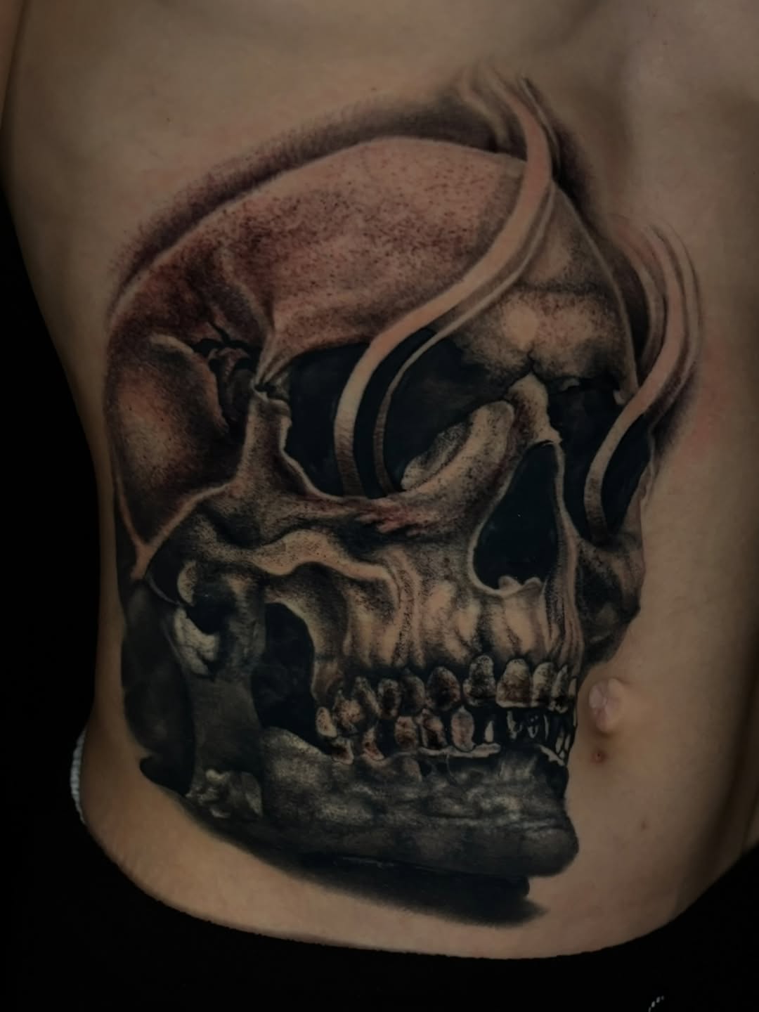 Skull with smoke realism tattoo on the ribs by @_frankyvee