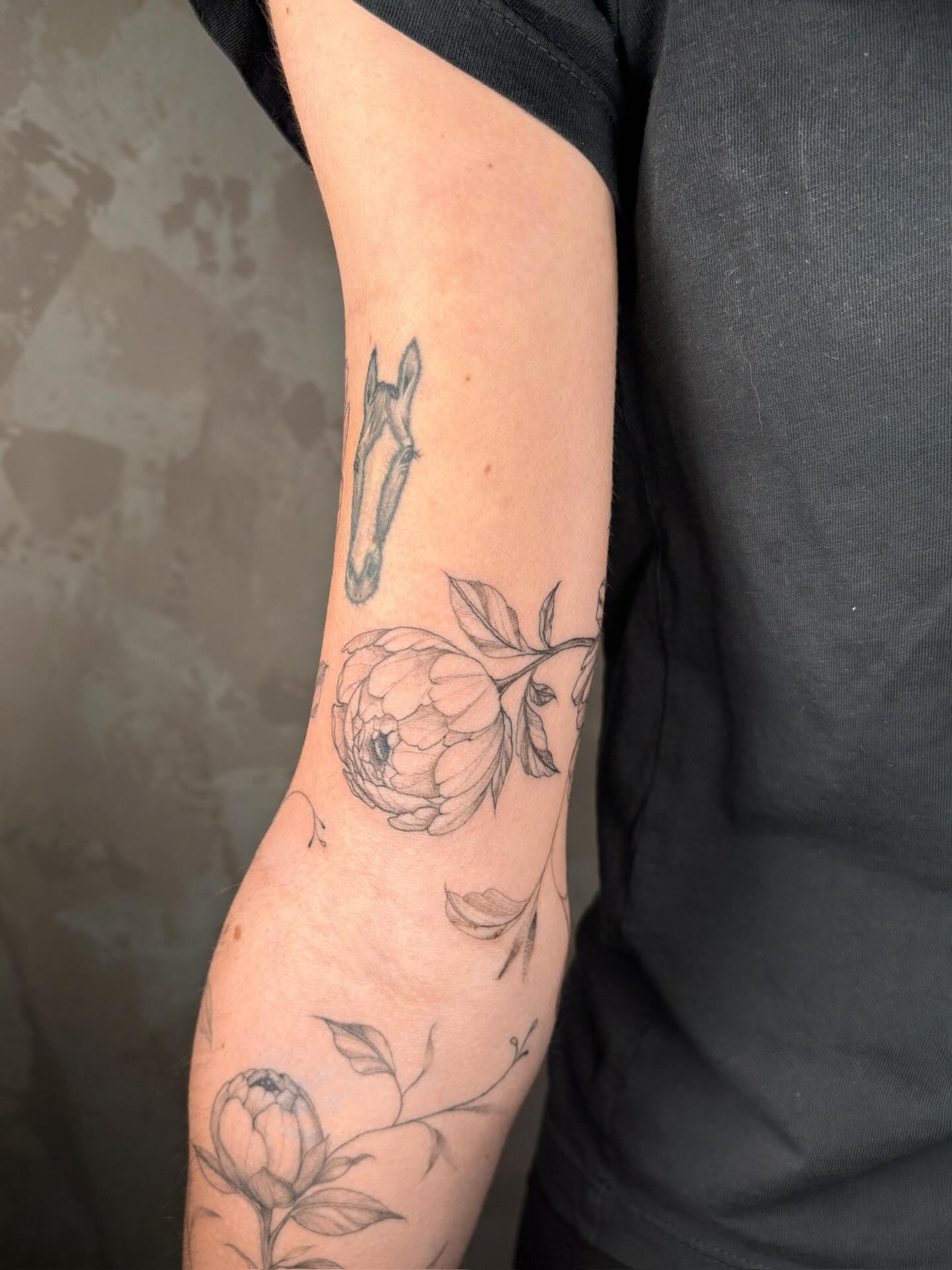 Peony and leaves black and grey tattoo on the forearm by Annie