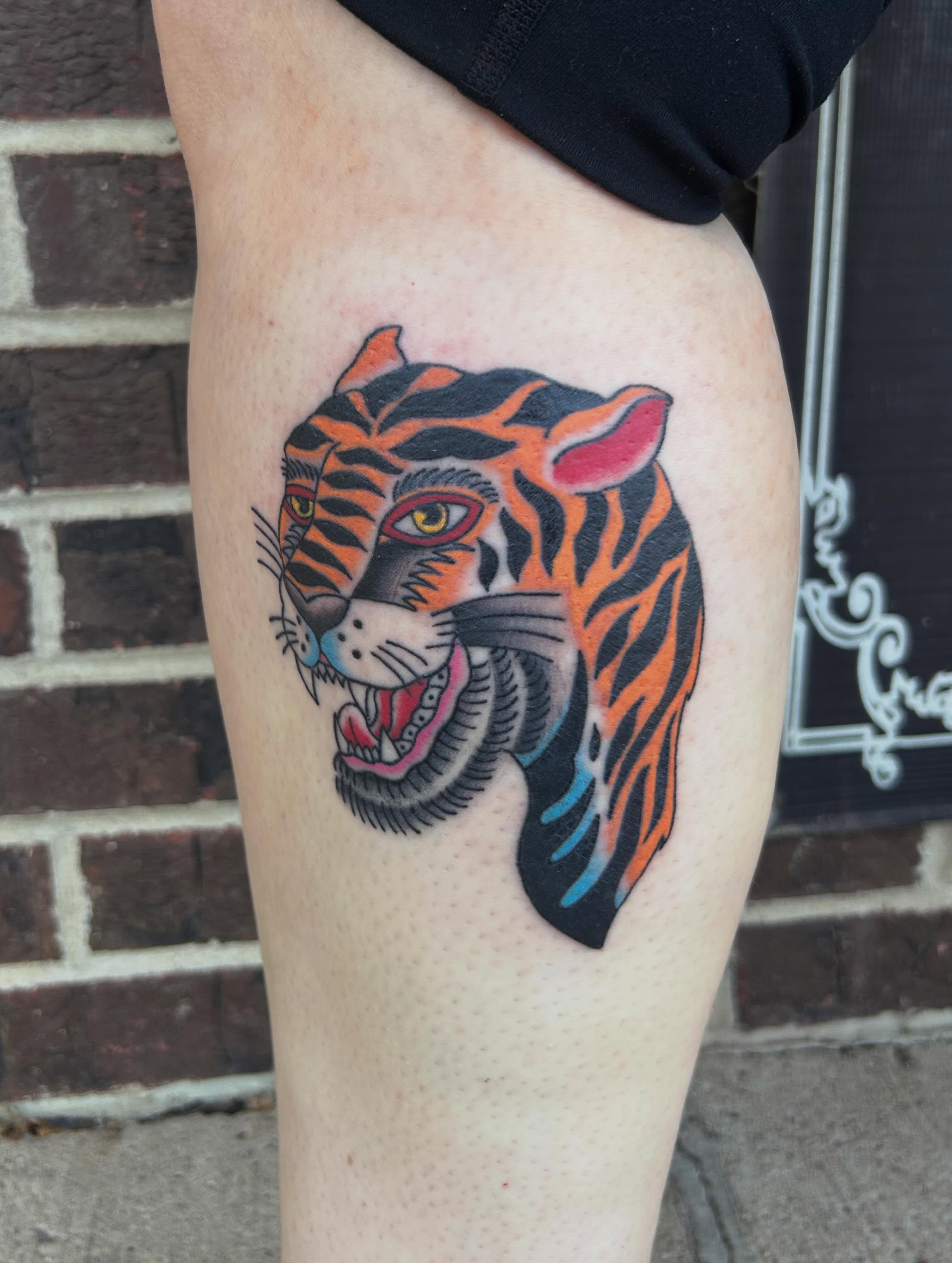 Tiger American traditional tattoo on the thigh by Zach Andrews