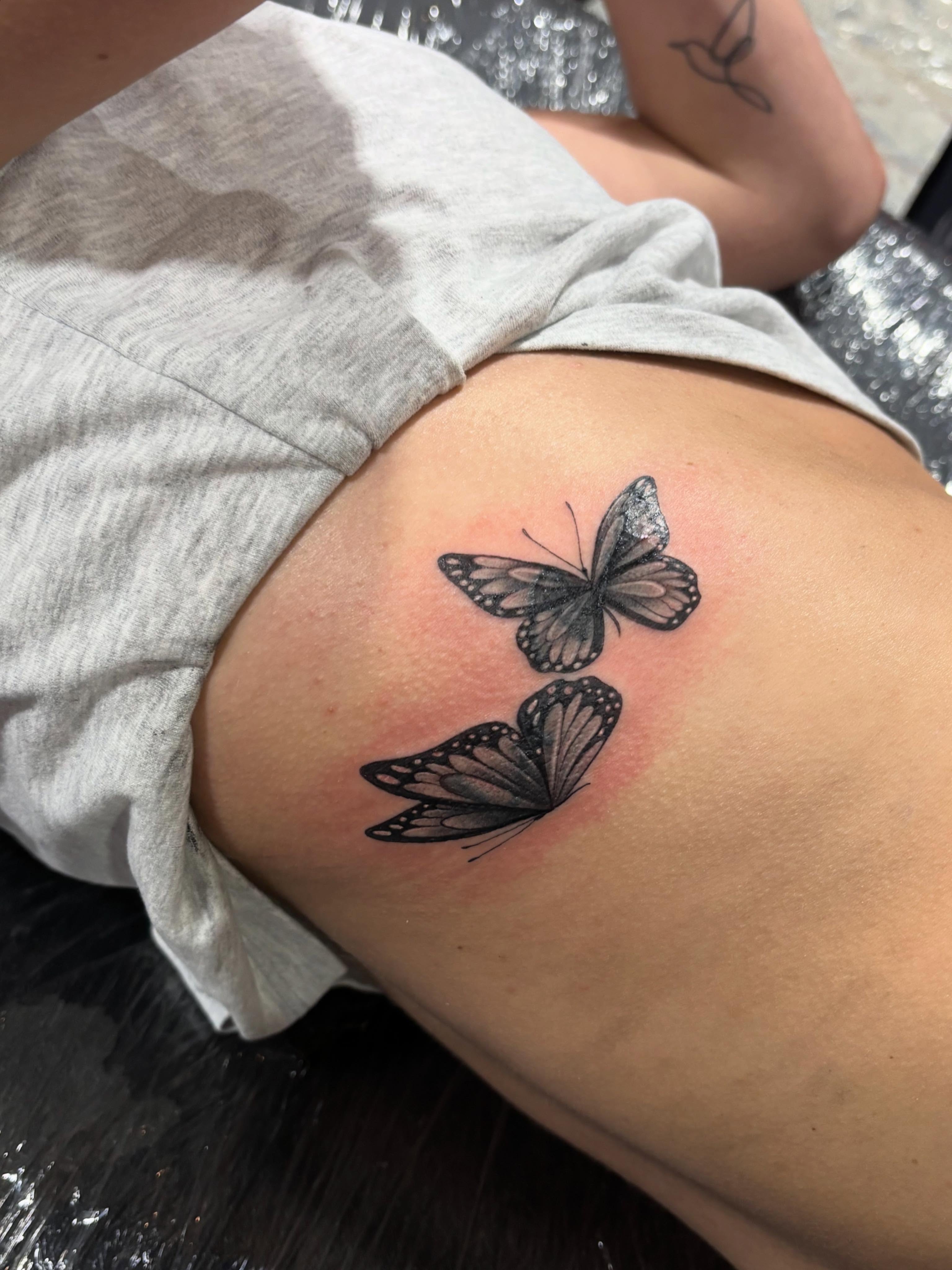 Butterflies black and grey tattoo on the thigh by Jennifer Flores